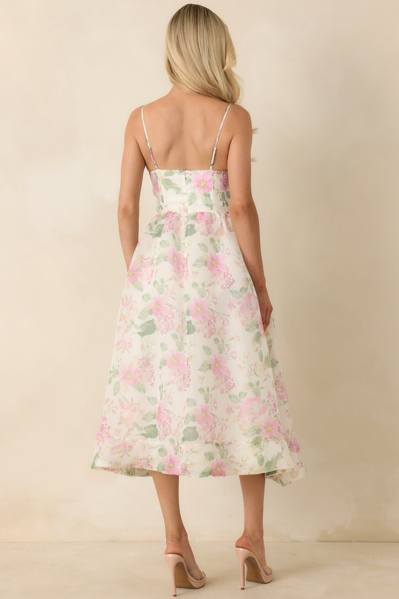 Back view of the floral midi dress featuring a smocked elastic panel, adjustable spaghetti straps, and a flowy midi-length silhouette.