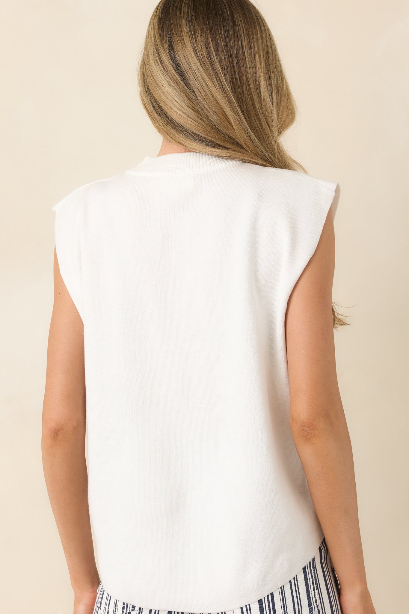 Back view of the ivory knit sleeveless top featuring clean lines, relaxed fit, and smooth stretch fabric.