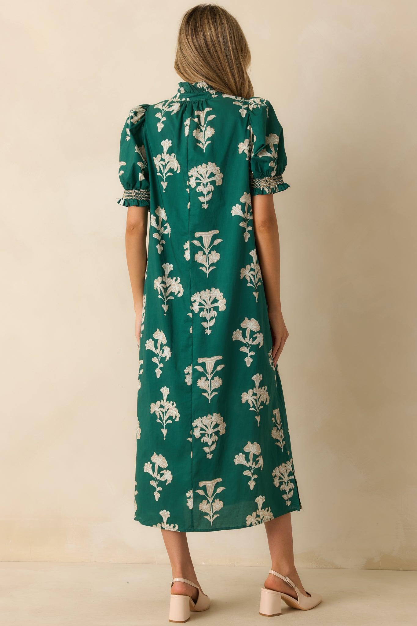 Back view of the green floral maxi dress featuring puff sleeves, smocked cuffs, and a relaxed drape.