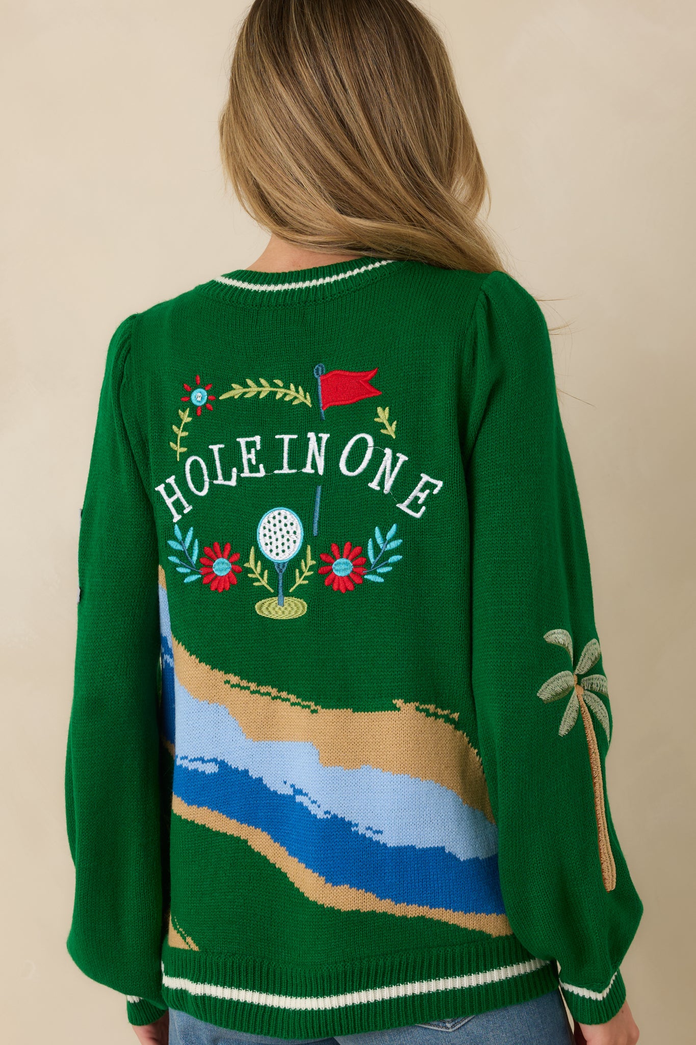 Back view of the green knit cardigan highlighting the continuous graphic pattern and relaxed knit drape.