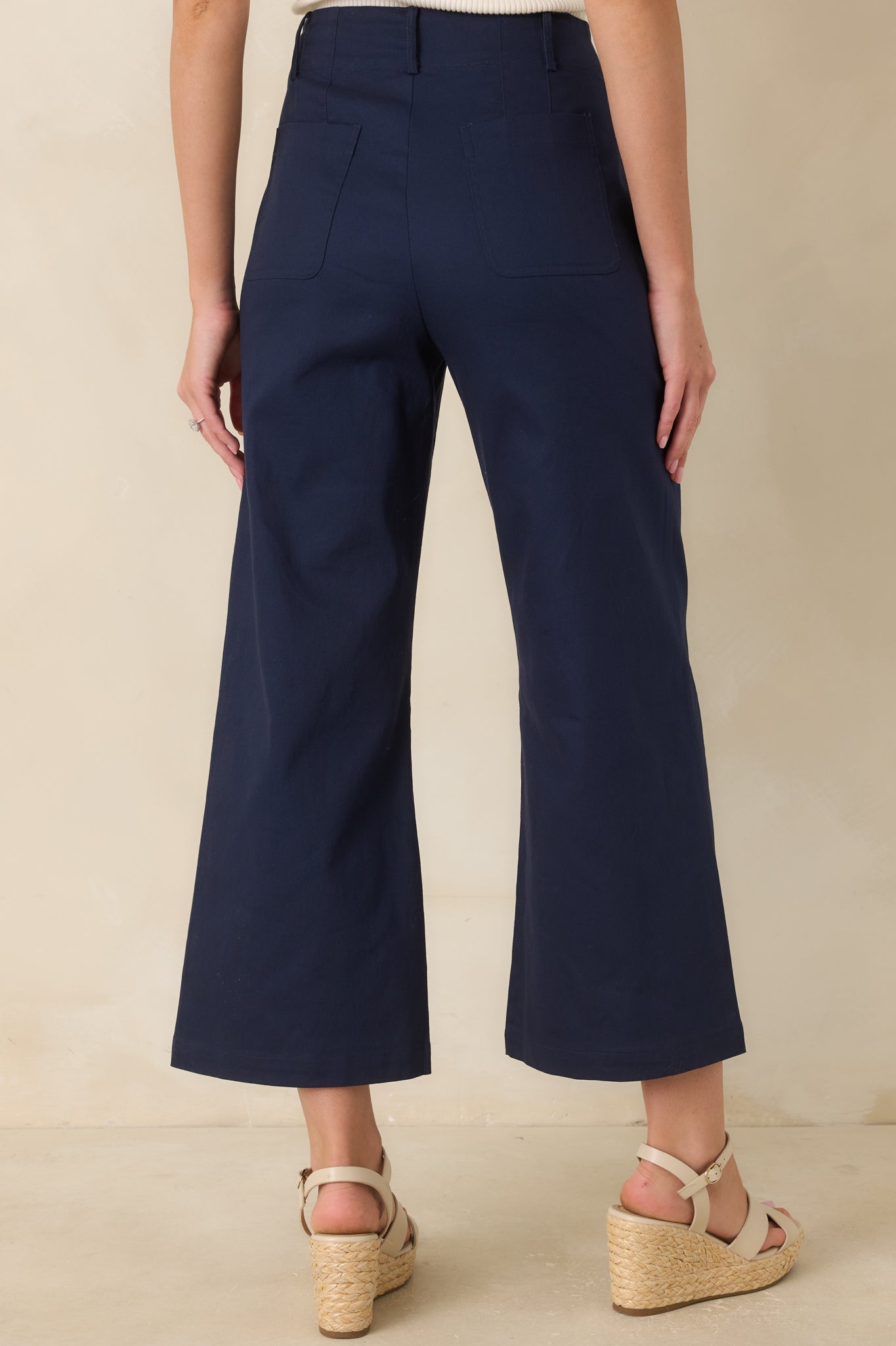 Back view of the high-waisted cropped pants featuring a wide-leg silhouette and functional back pockets.
