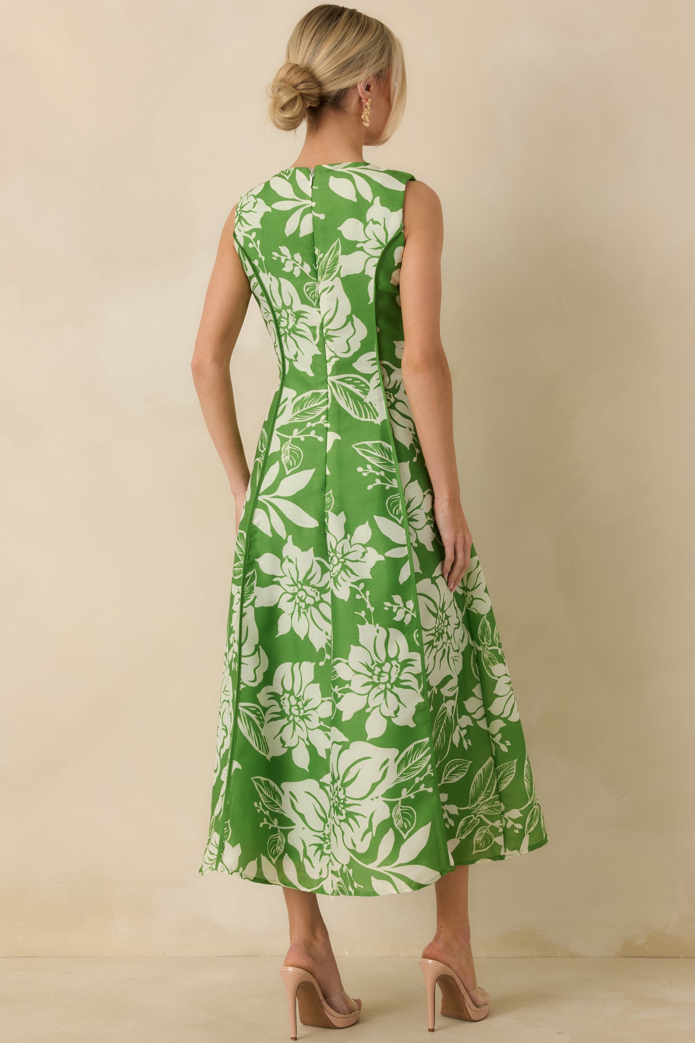 Back view of the green floral midi dress highlighting the hidden zipper, tailored fit, and softly flared skirt.