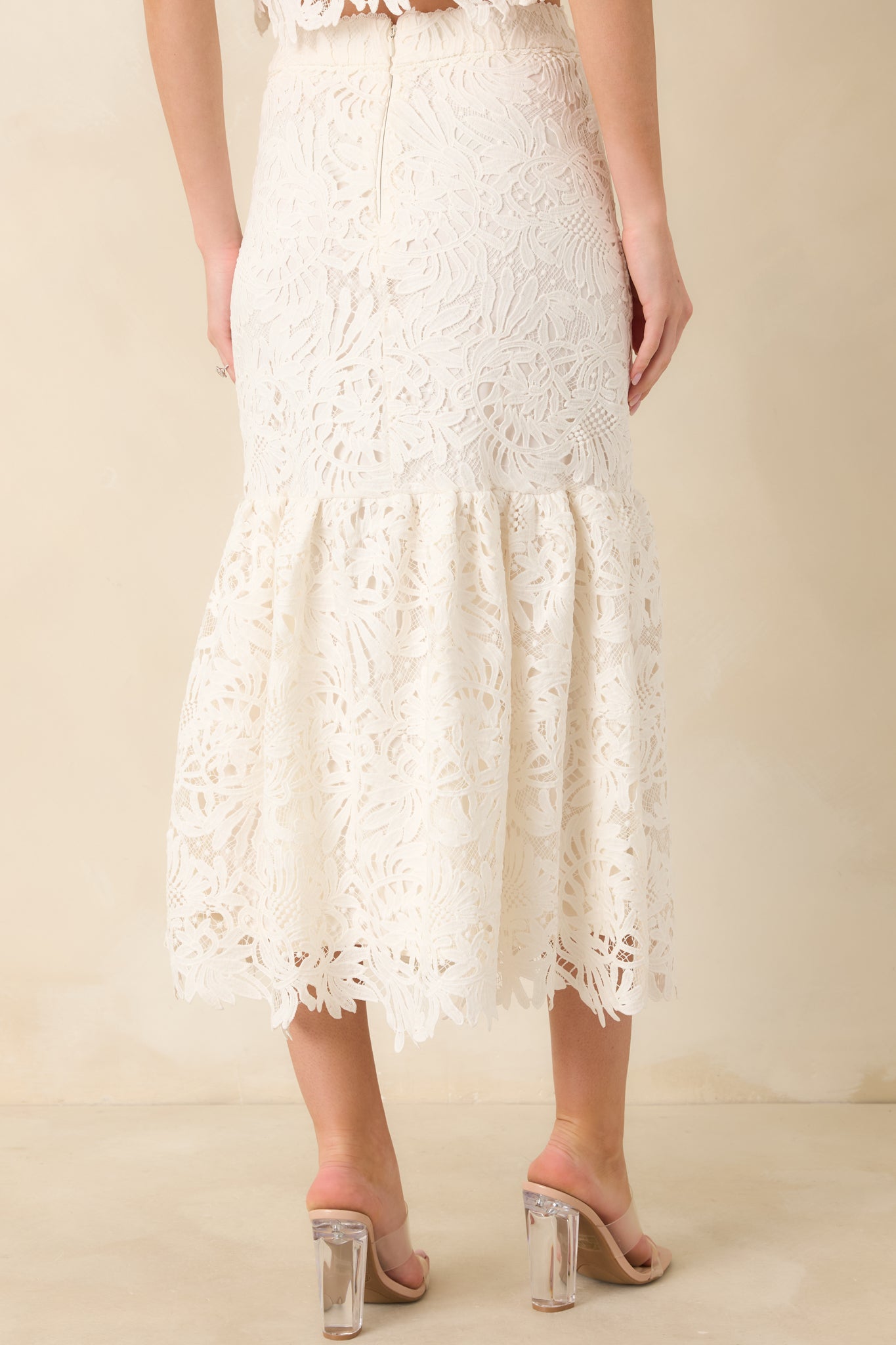 Back view of the ivory midi skirt highlighting the lace overlay and flared ruffle panel from the back.