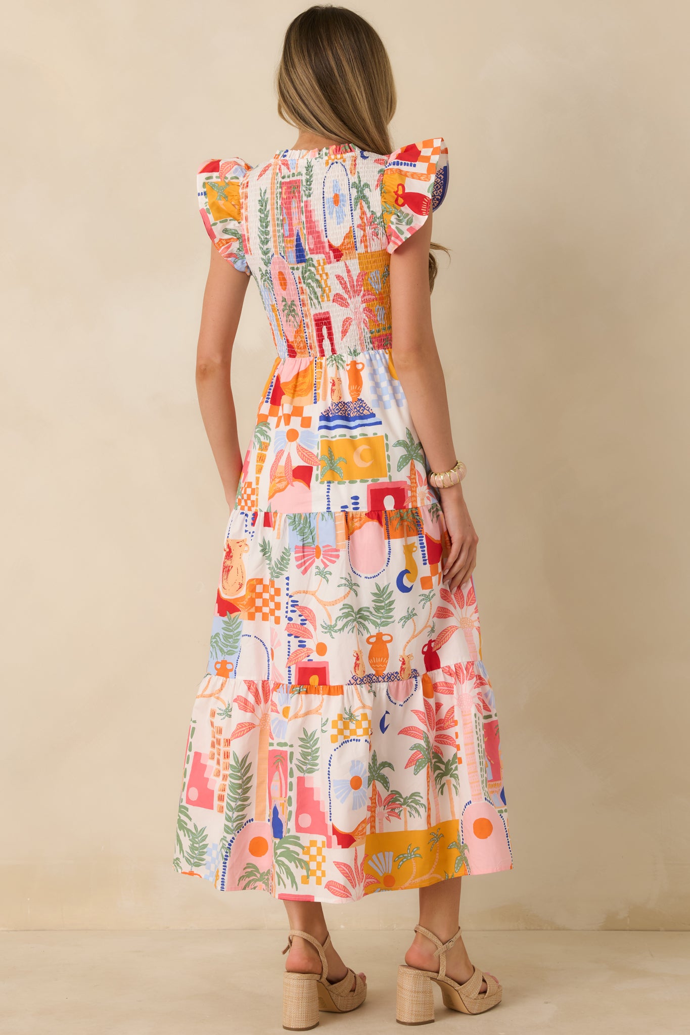 Back view of the orange and pink maxi dress highlighting the relaxed fit, tiered skirt, and lightweight woven fabric.