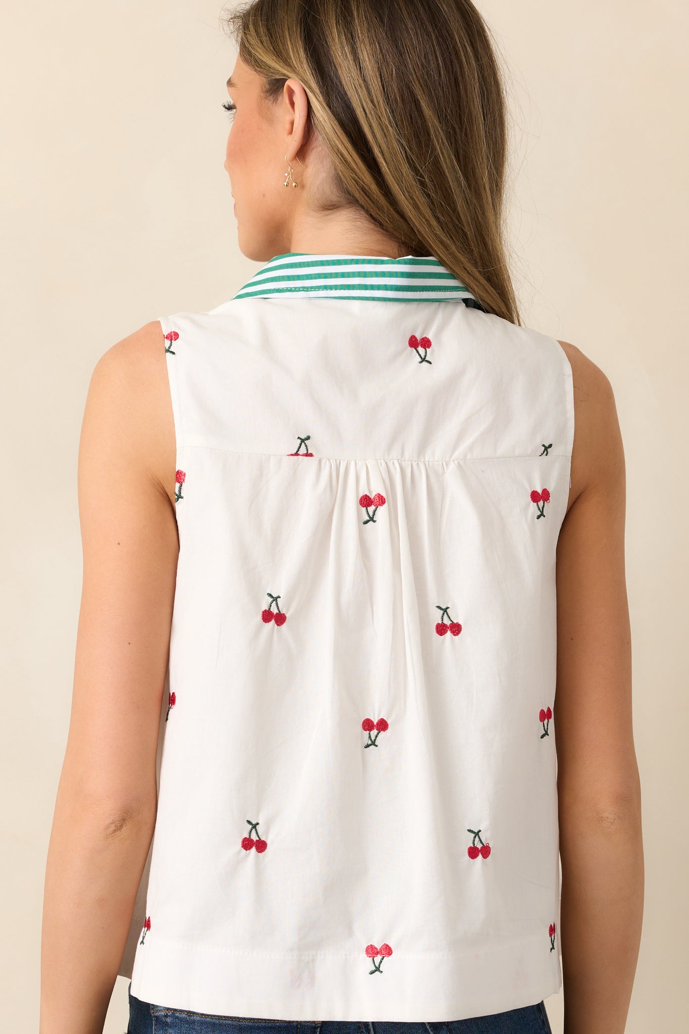 The back view highlights the smooth ivory fabric and easygoing fit, making this blouse a versatile wardrobe staple.