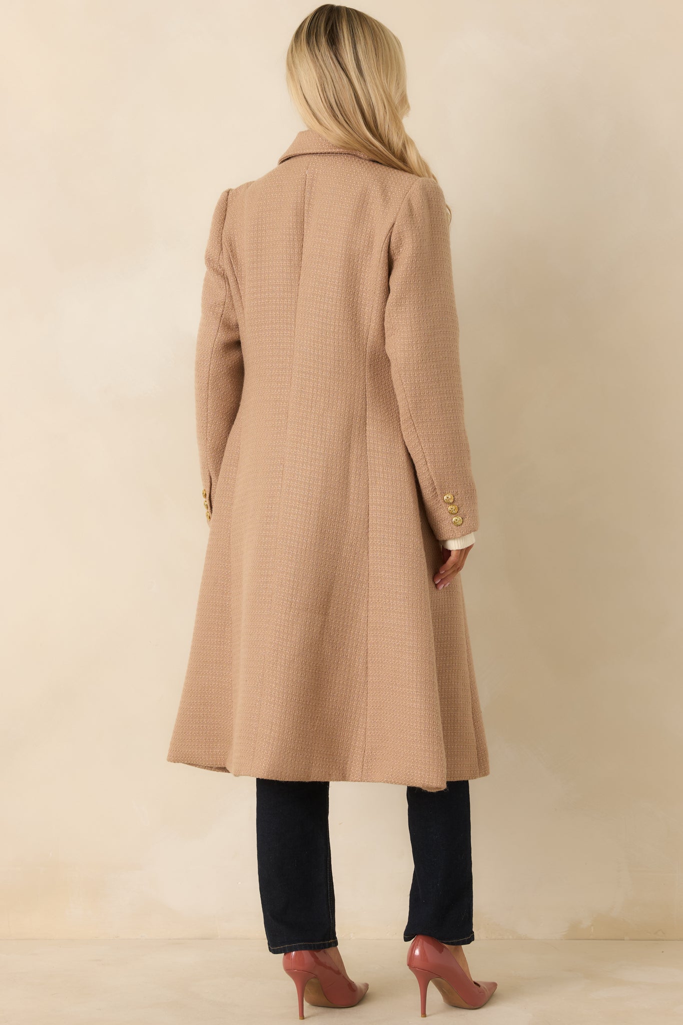 Back view of the camel double-breasted topcoat highlighting the structured silhouette and long sleeves.