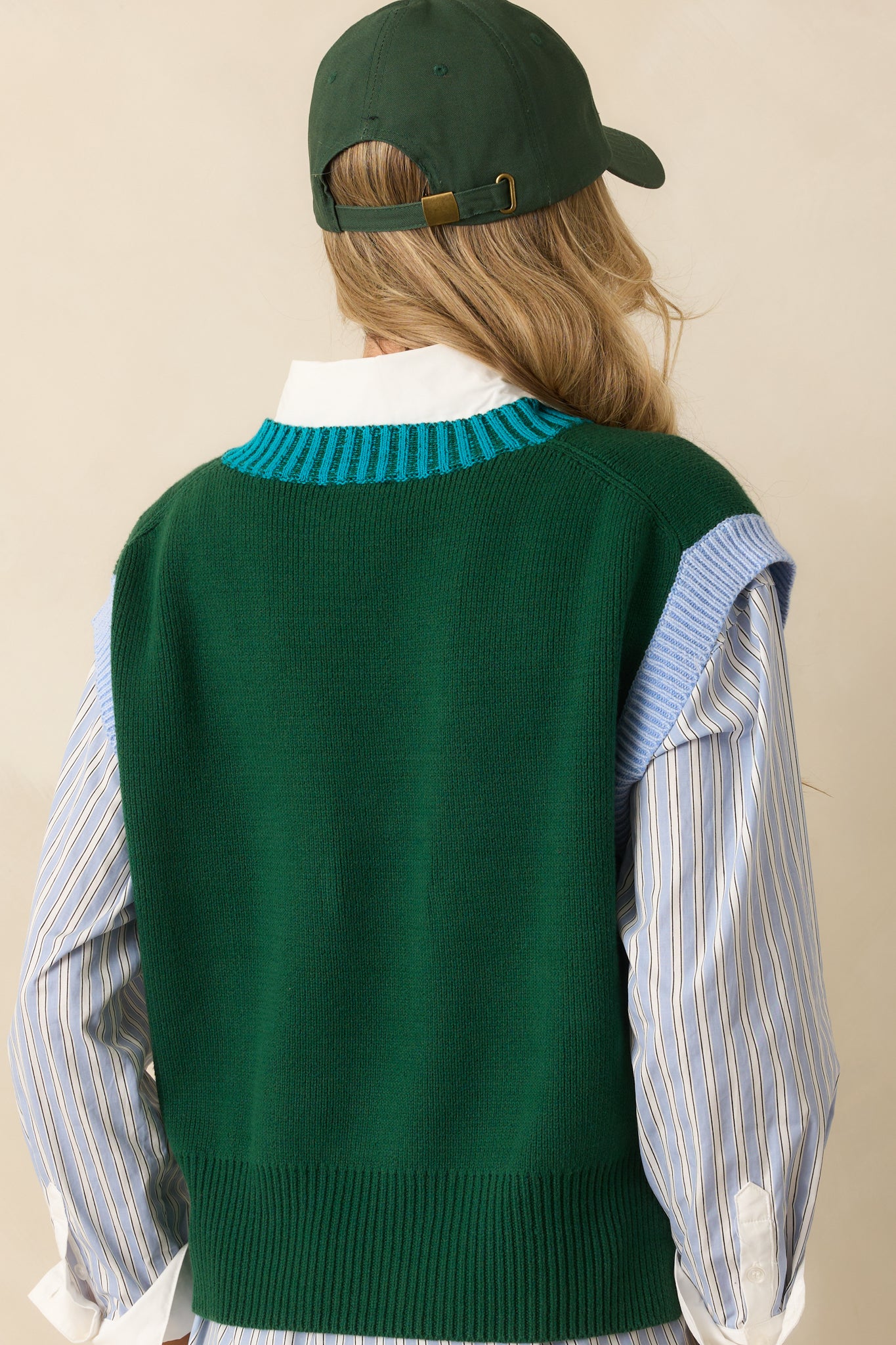 A back view of the hunter green sweater vest highlighting the straight hem and relaxed cut.
