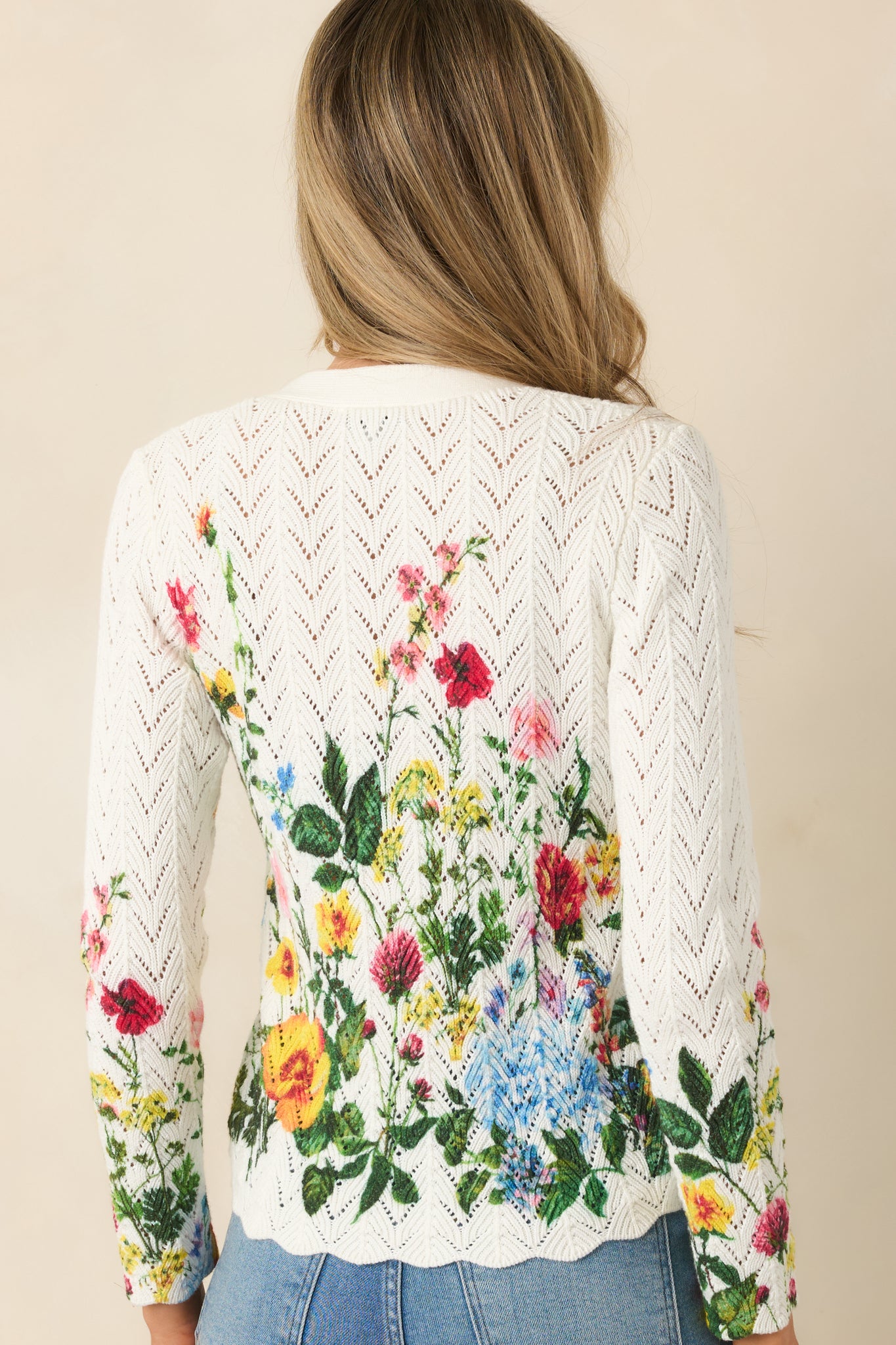Back view of the ivory long sleeve cardigan featuring lightweight pointelle knit and fitted sleeve design.