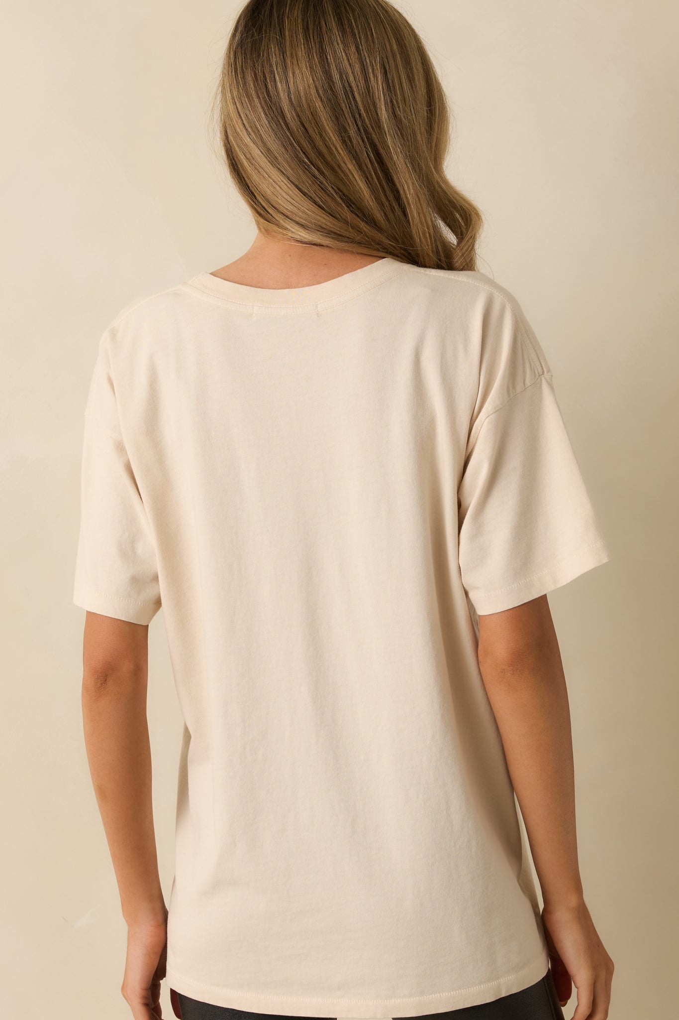 Back view of the ivory graphic tee showing the solid ivory color and relaxed silhouette.