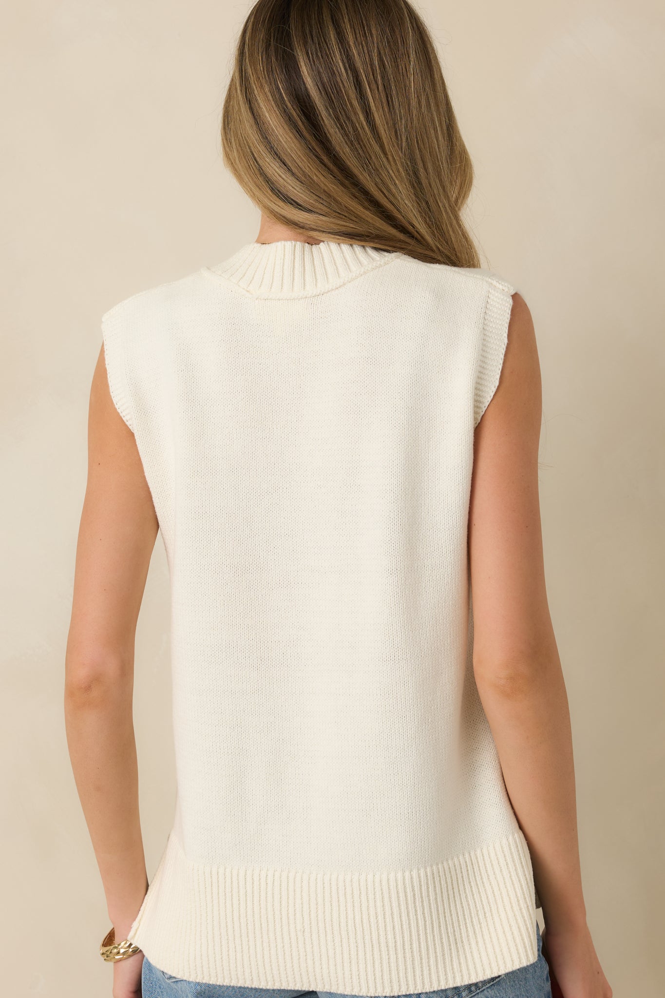 Back view of the ivory knit sweater vest showing smooth knit fabric and relaxed fit.