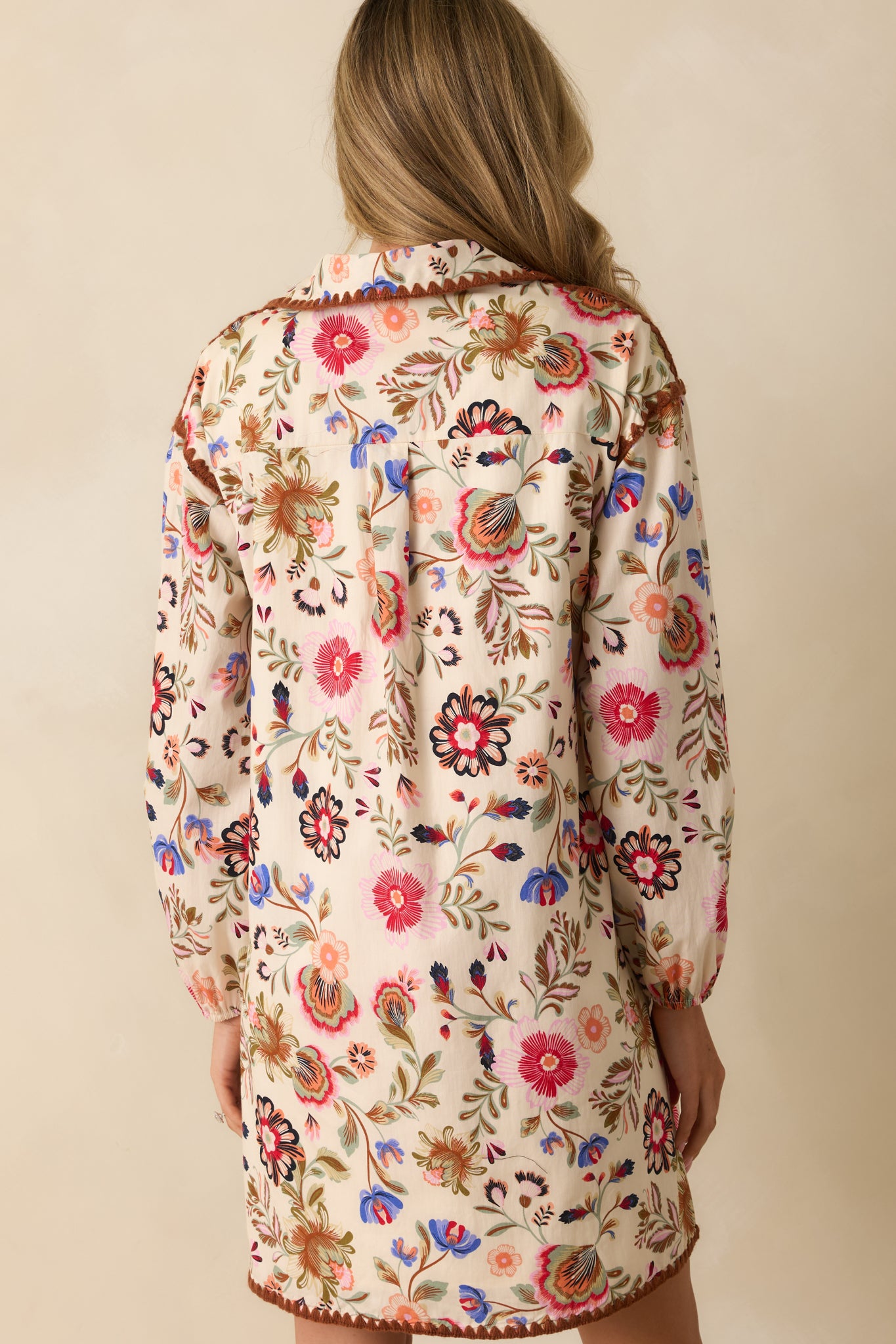 Back view of the ivory shift dress showing the floral print and relaxed silhouette.