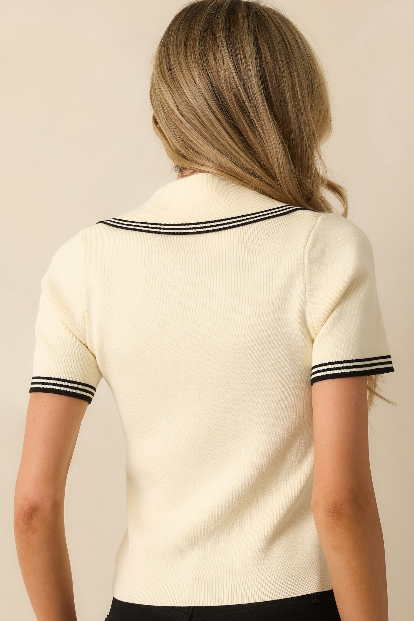 A back view of the ivory shirt showing the fitted design, short sleeves, and clean back.