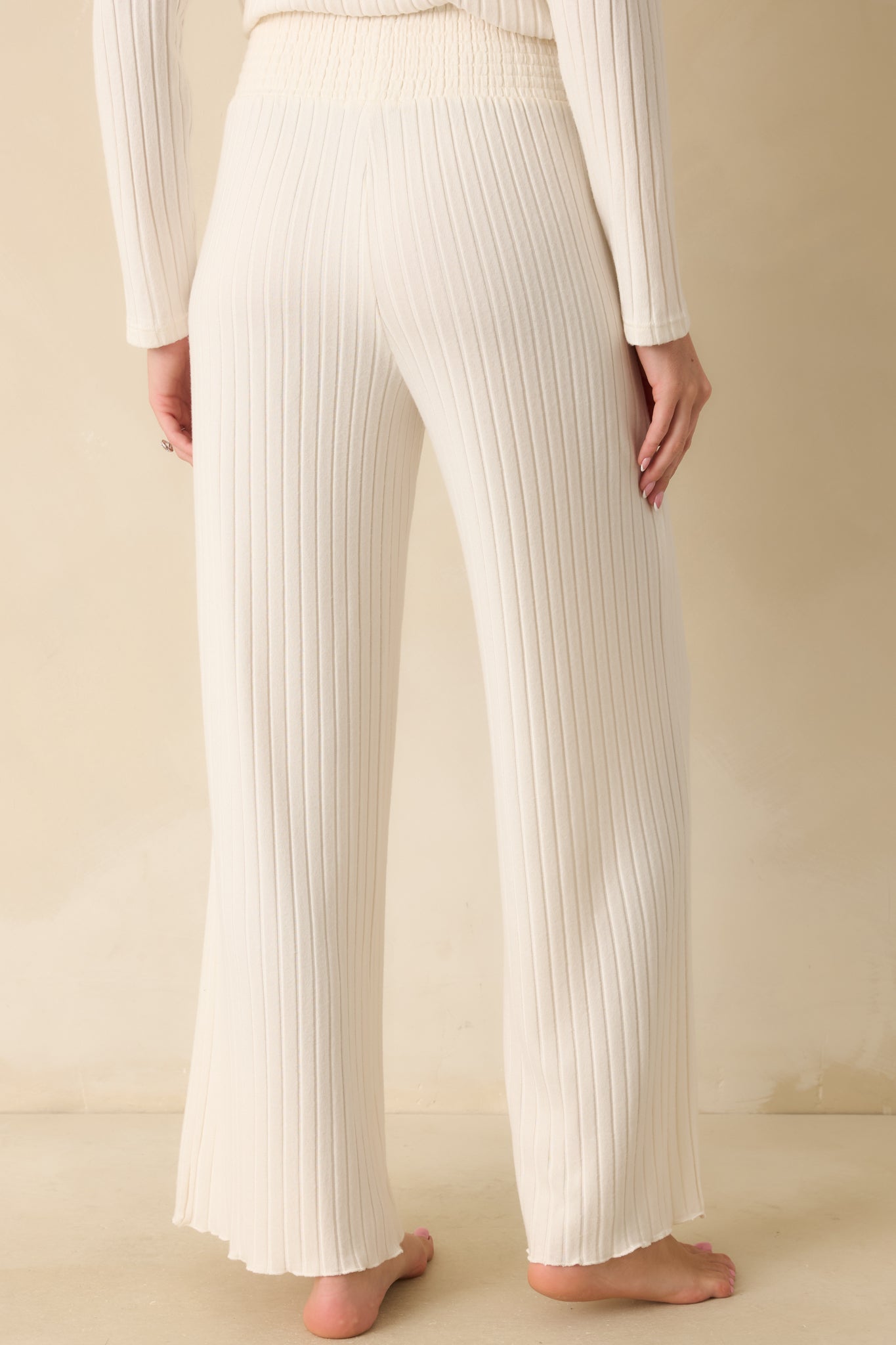 Back view of the ivory pants showing the wide-leg fit and smocked waistband.