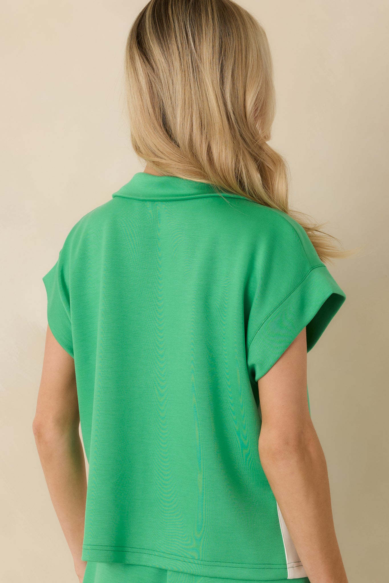 Back view of the Kelly green knit top showing clean lines and relaxed fit

