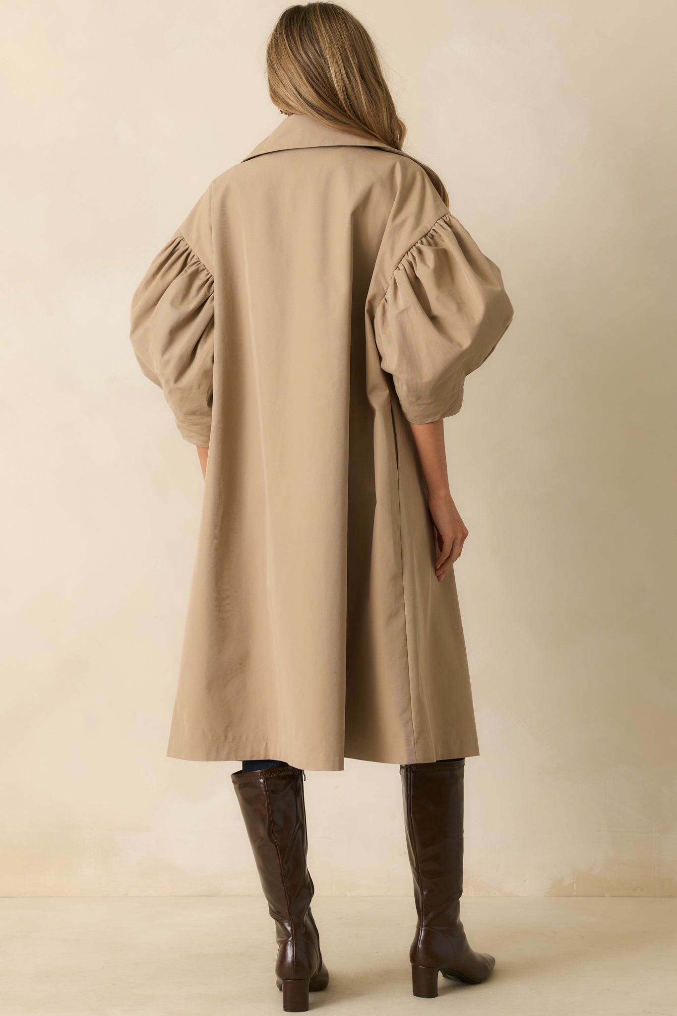 Rear view of the khaki coat with puff sleeves and a relaxed drape.