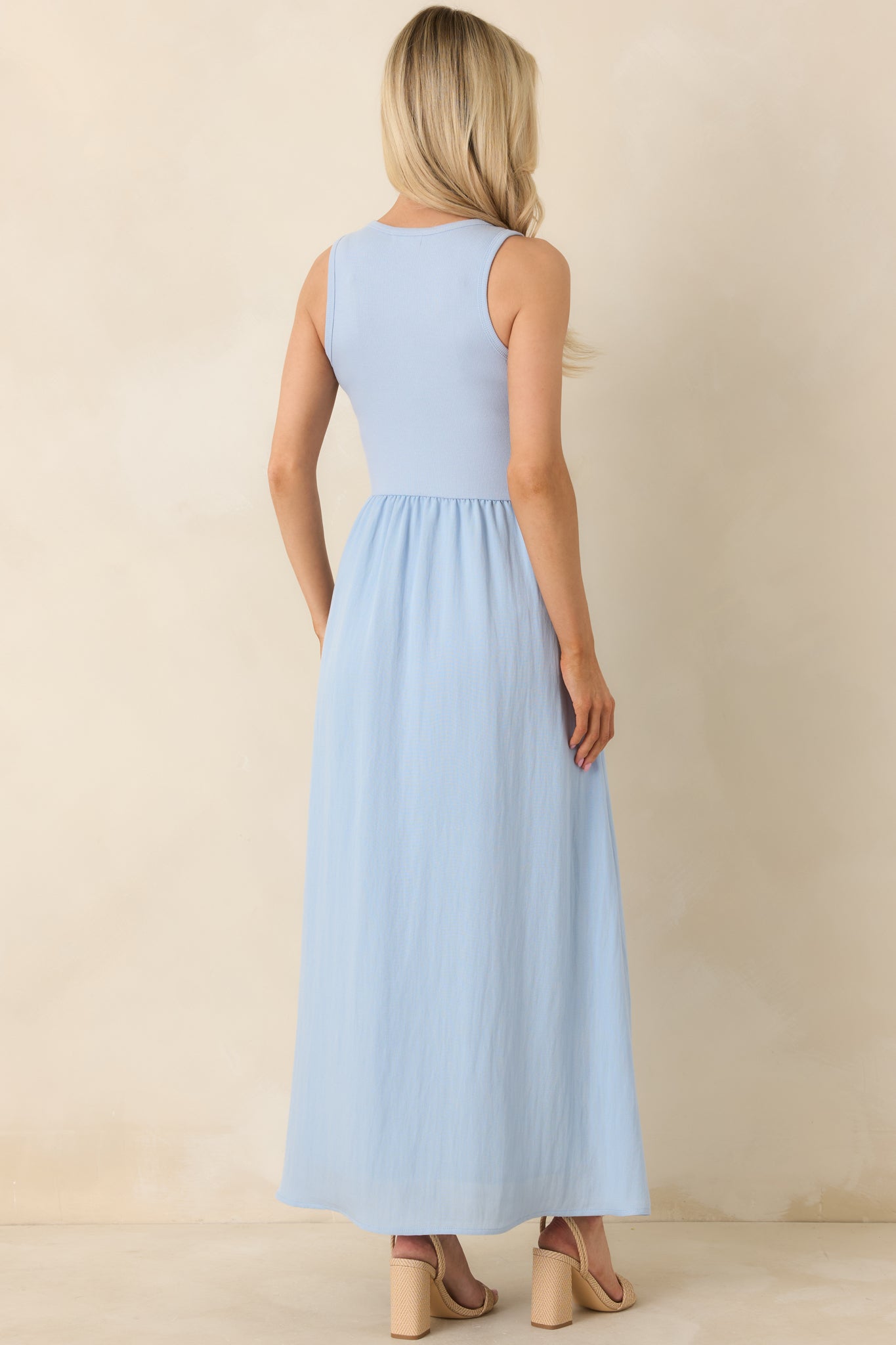 Back view of the light blue midi dress displaying the sleeveless cut and textured skirt from behind.