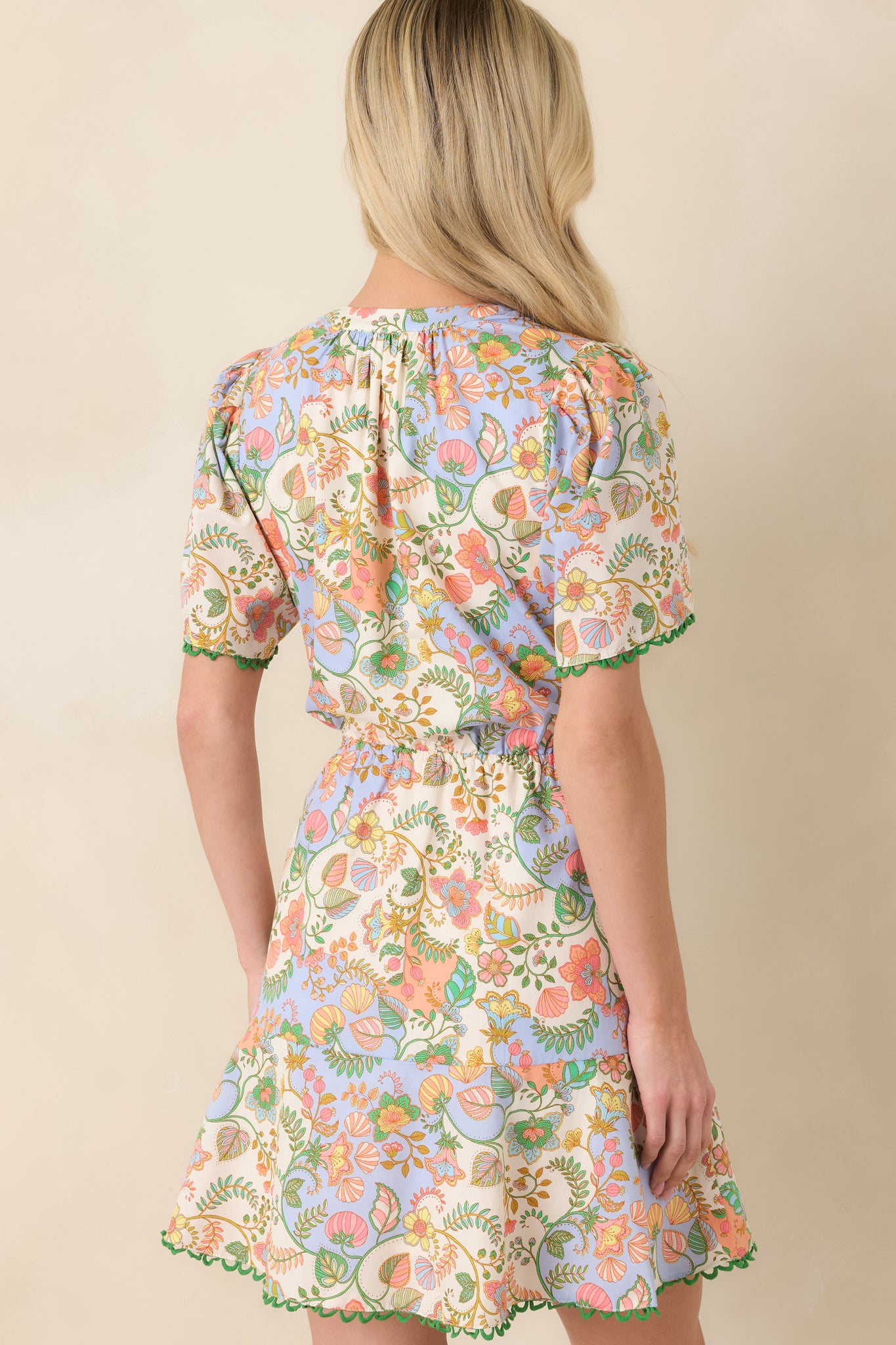 Back view of the mini dress displaying the relaxed fit, elasticized waist, and tiered skirt for added movement.