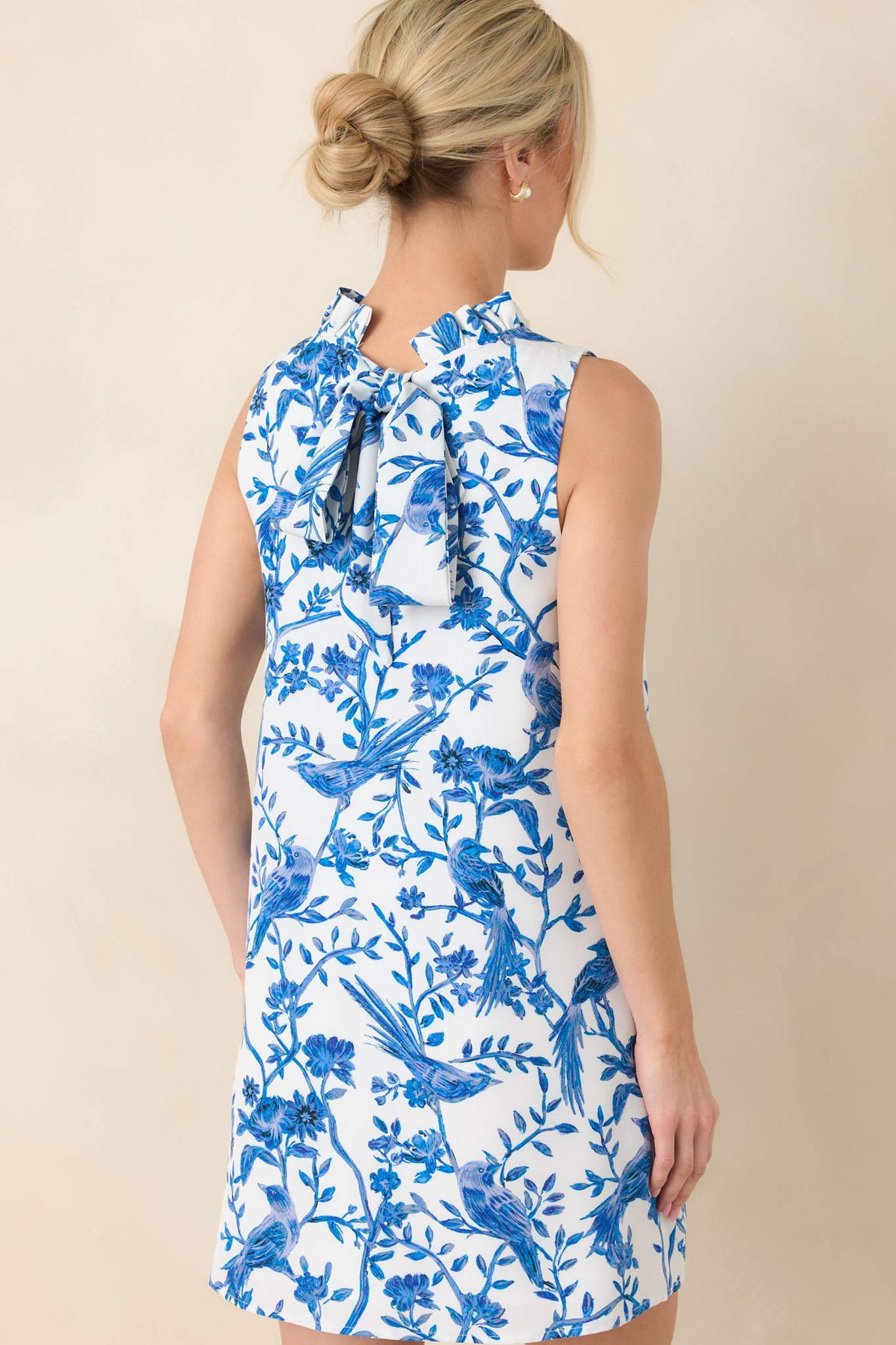 Back view of the mini dress featuring the keyhole with self-tie bow closure and smooth shift silhouette.