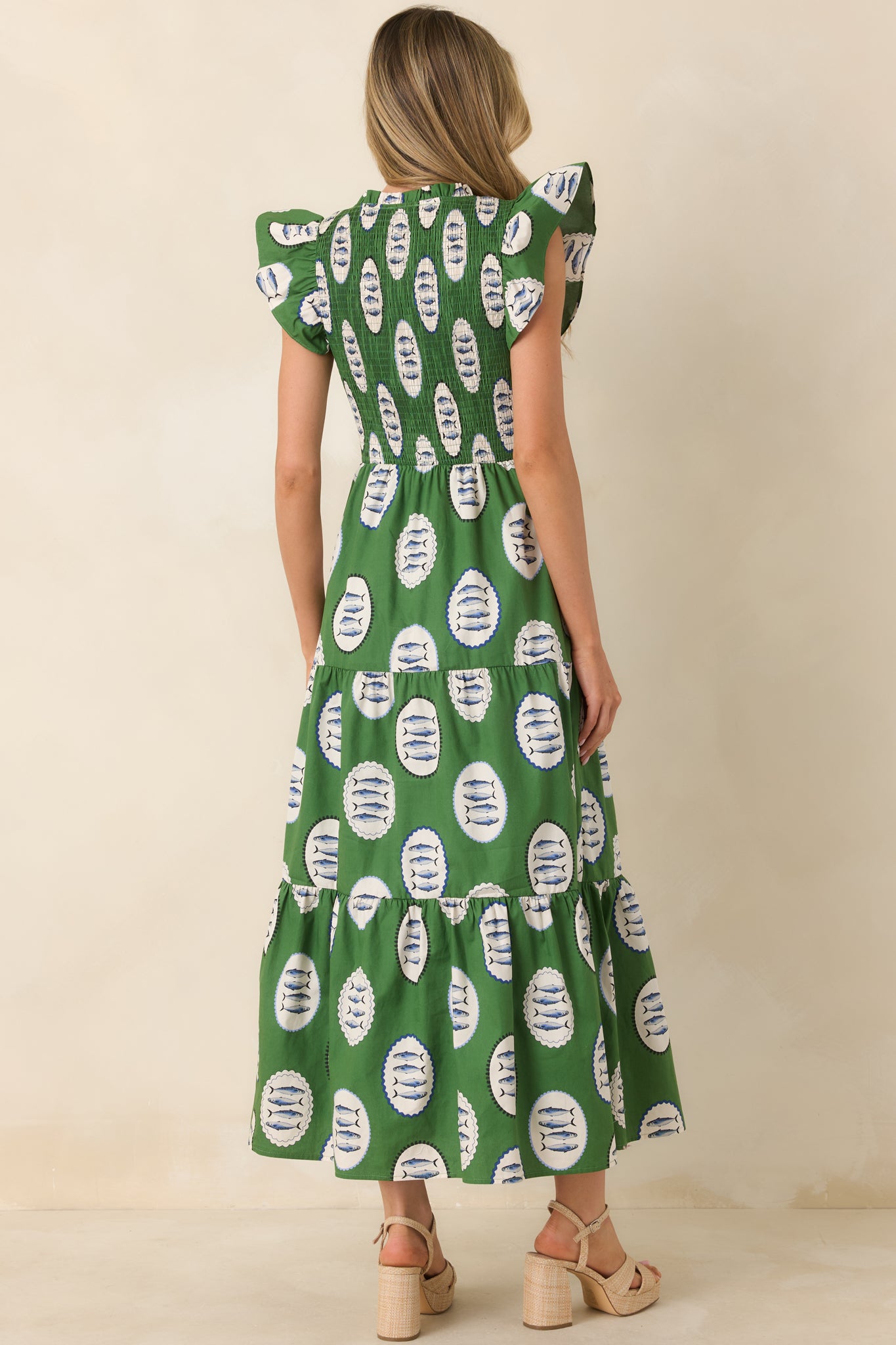 Back view of green maxi dress highlighting smocked bodice, tiered skirt, and flowing silhouette