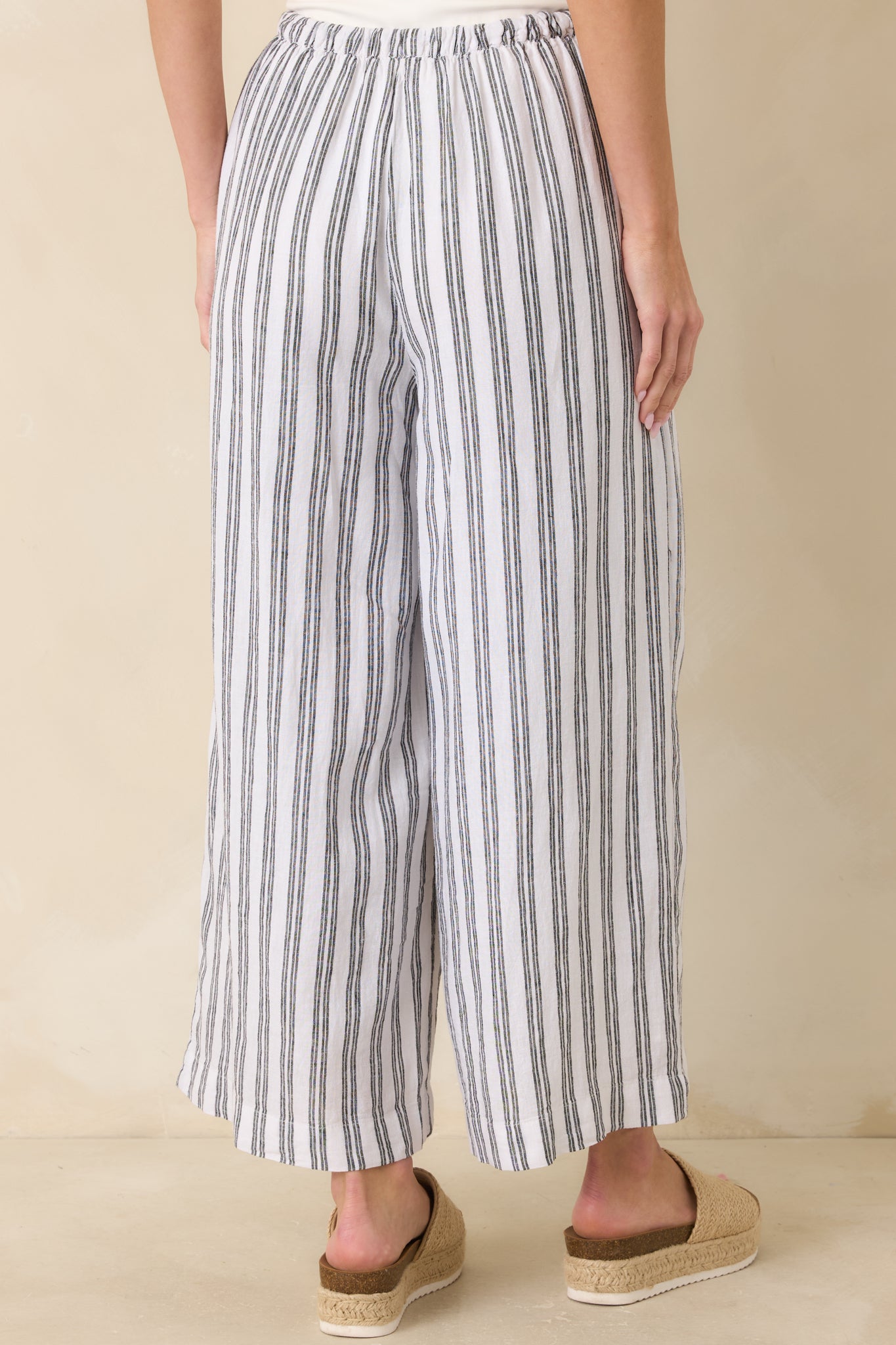 Back view of black and white striped pants showcasing high-rise fit and relaxed wide-leg silhouette.