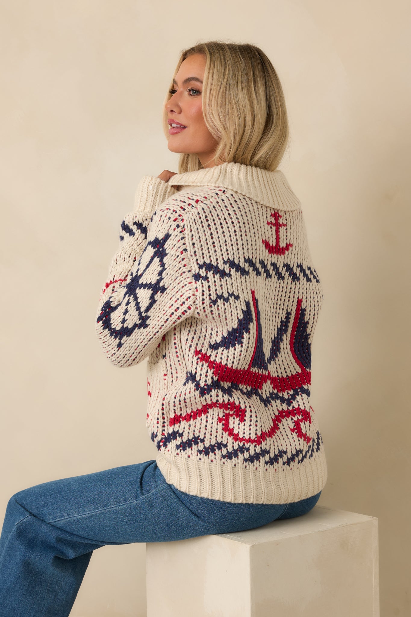 Back view of ivory multi-knit jacket showing chunky knit texture, nautical motif, and ribbed hem.