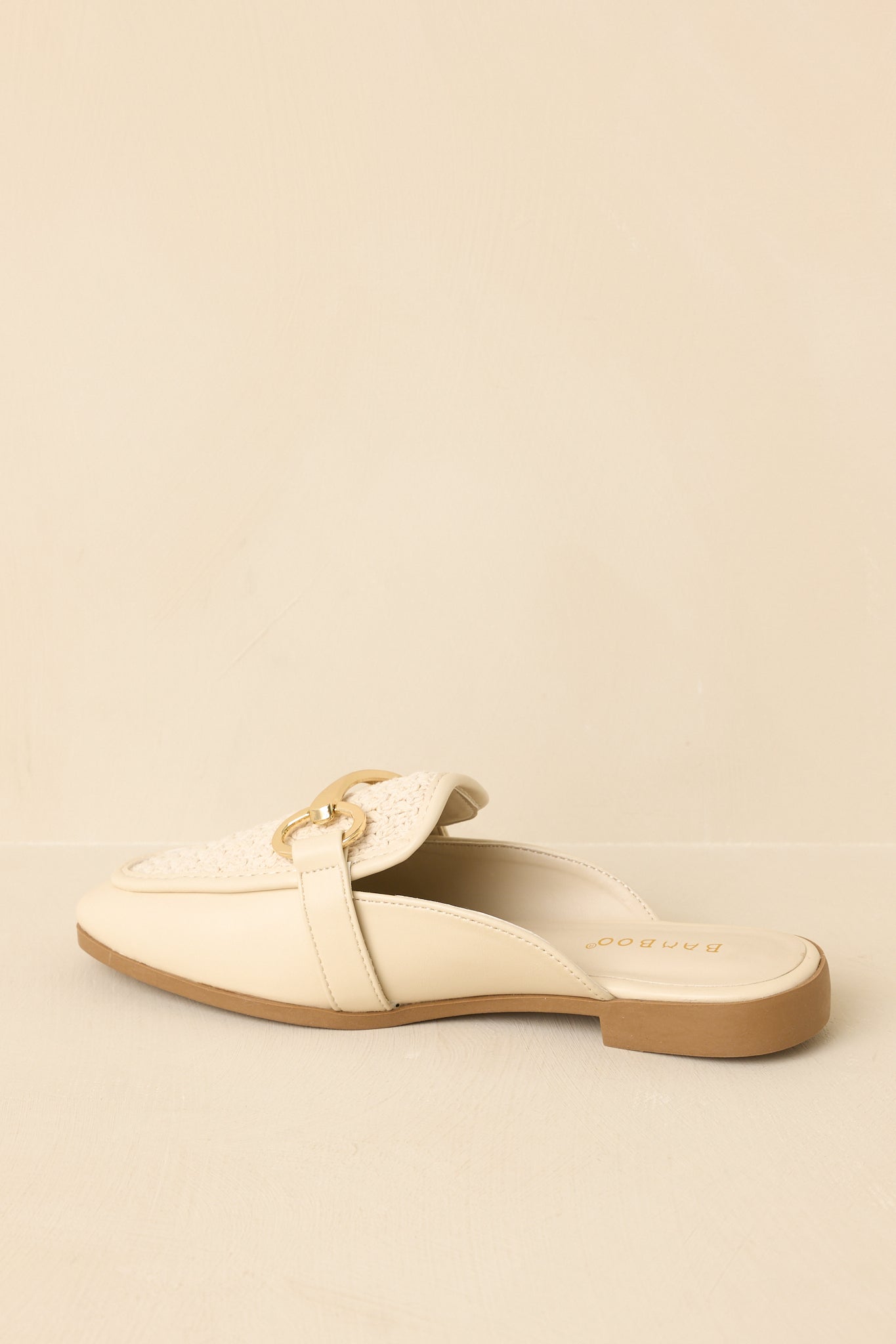 Back view of ivory woven faux leather mule loafers showcasing the open-back slip-on design and flat sole.