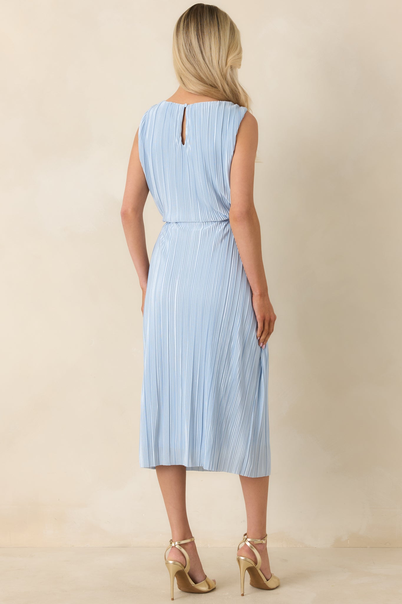 Back view of light blue pleated midi dress showing keyhole opening with button closure and smooth drape.