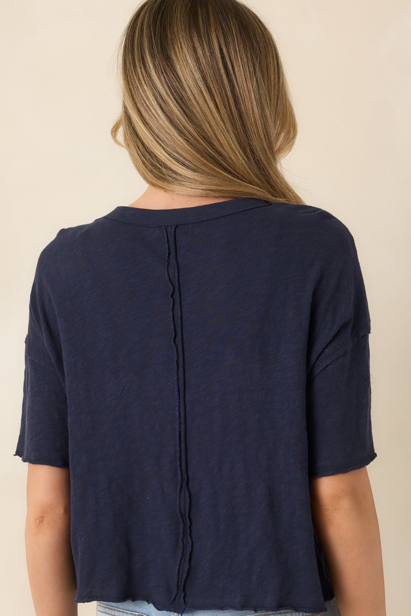 Back view of navy cotton tee showing relaxed silhouette and clean back neckline.