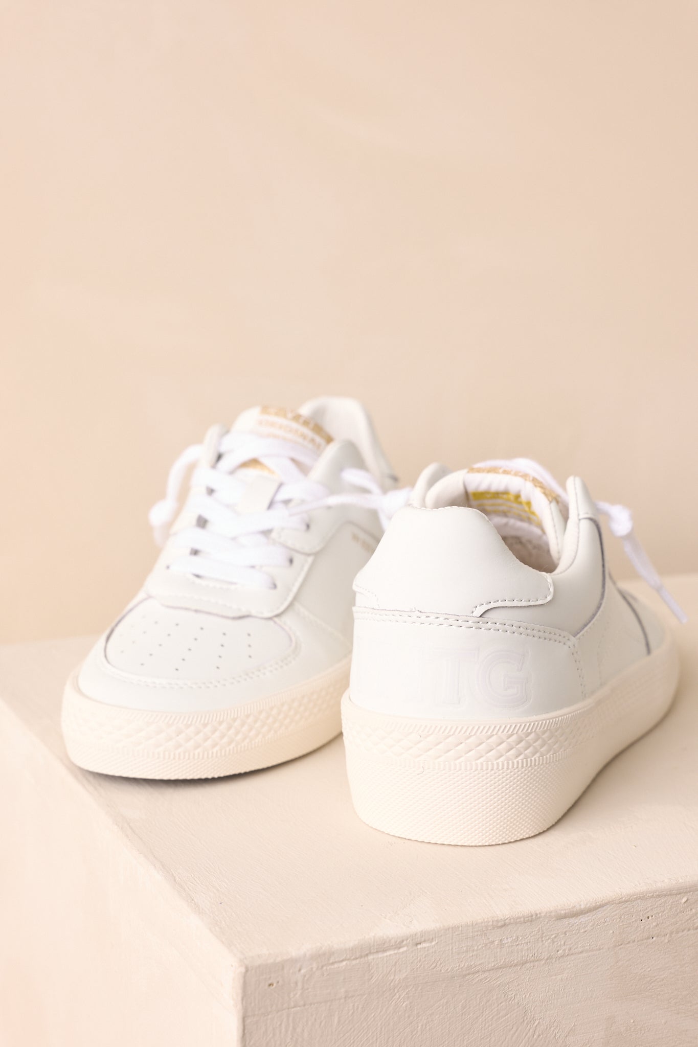 Back view of the sneakers highlighting the heel shape, platform sole, and distressed leather texture.