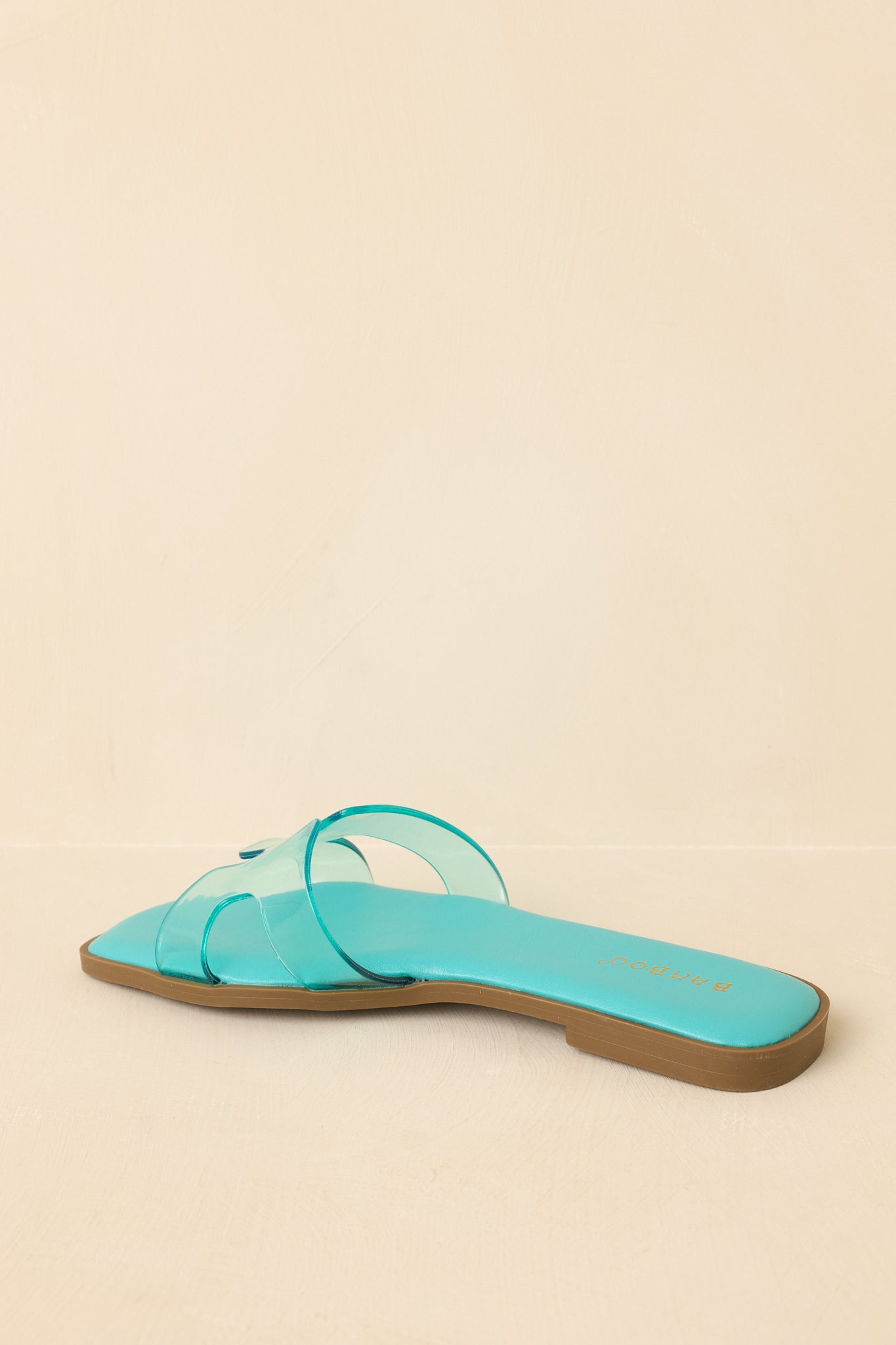 Back view of teal slide sandals showing open heel and flat sole construction.