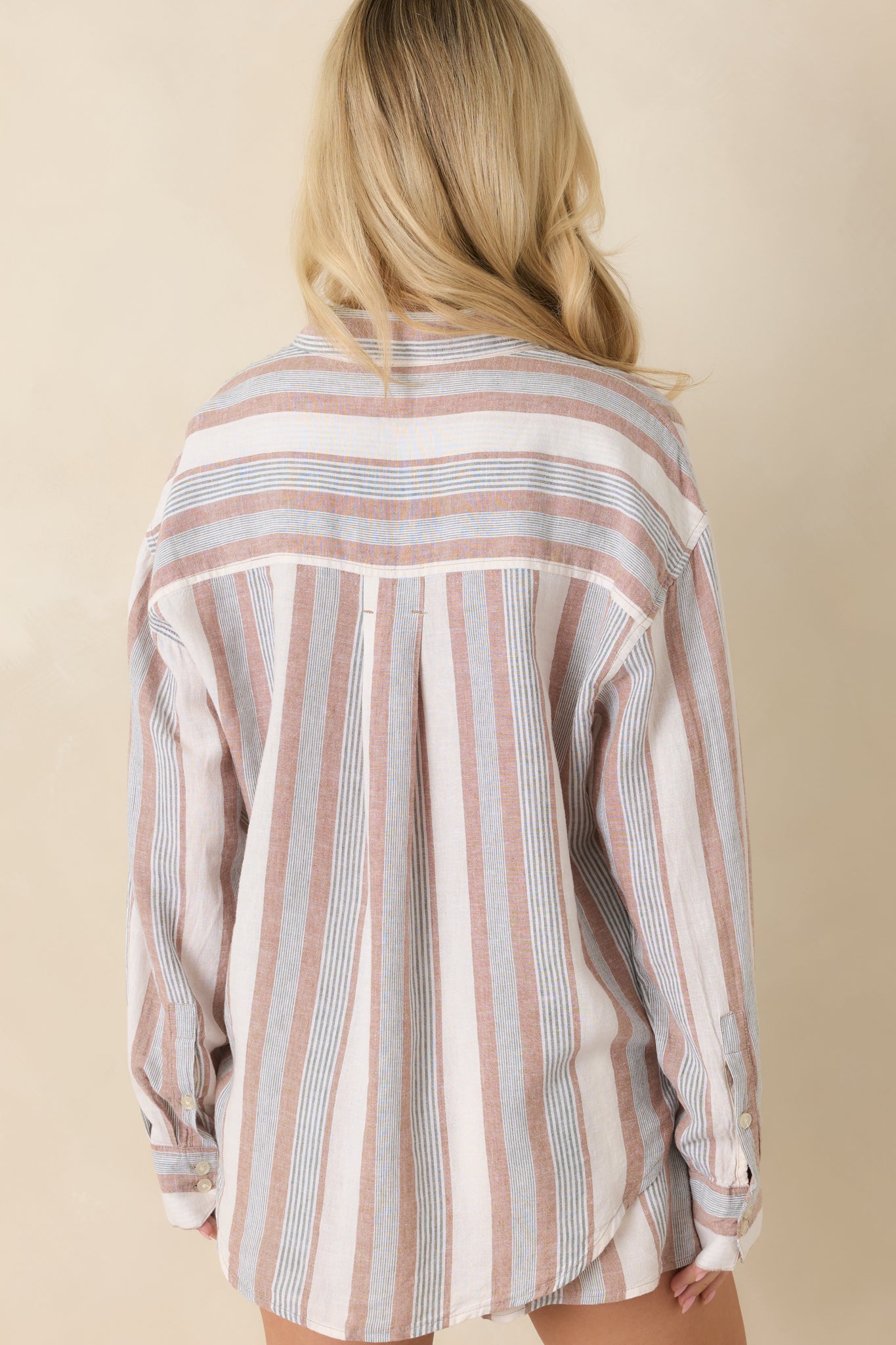 Back view of the beige and green striped top featuring long sleeves, a relaxed drape, and lightweight breathable construction.