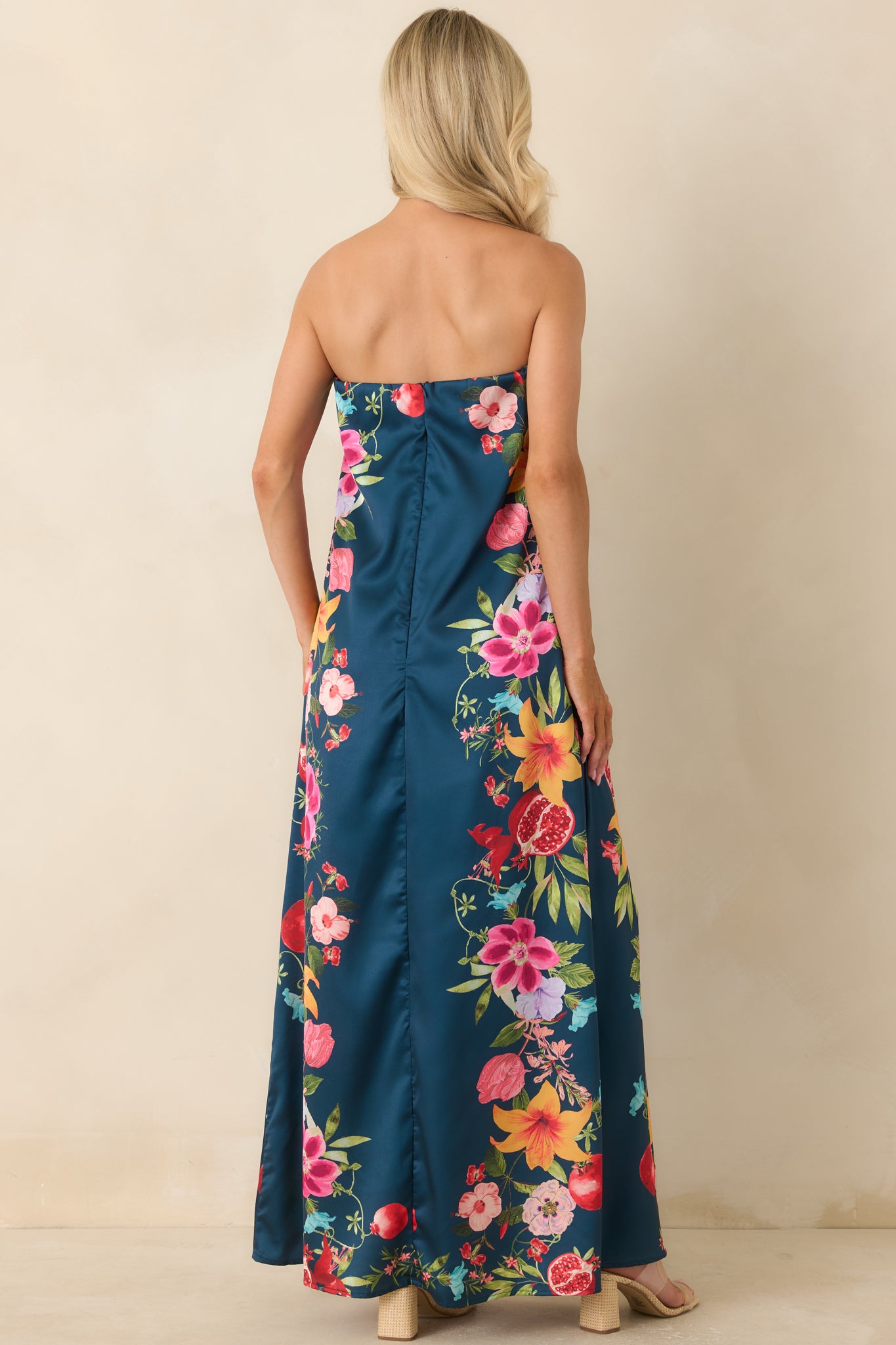 Back view of the navy multi floral maxi dress showcasing the flowing maxi silhouette and concealed back zipper closure.