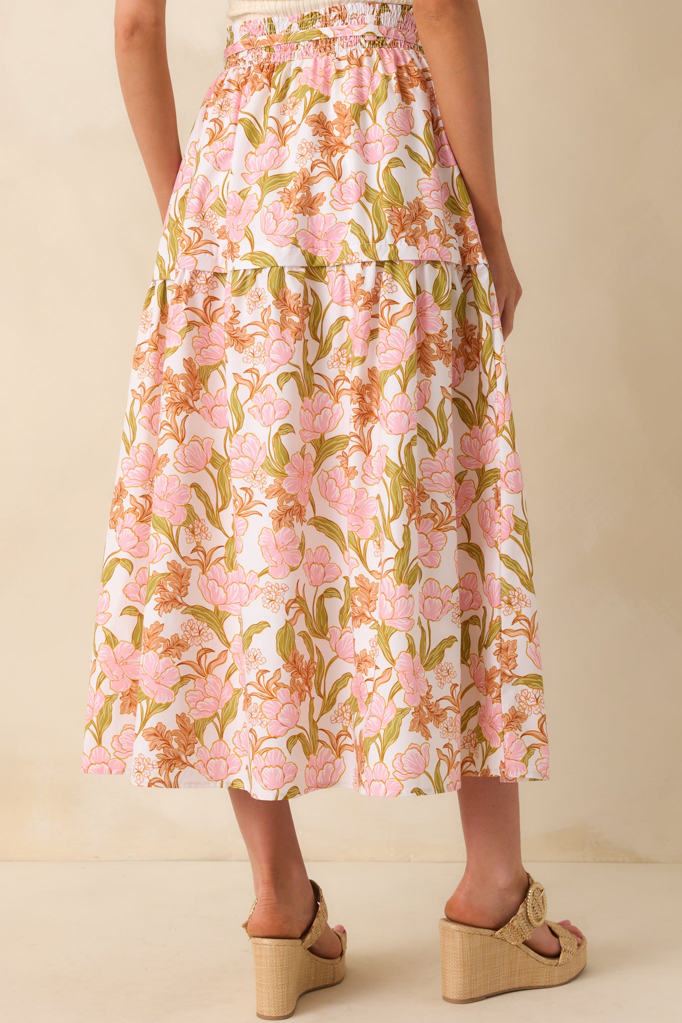 Back view of the skirt displaying the smocked back waistband, flow of the tiered design, and continuation of the floral print.