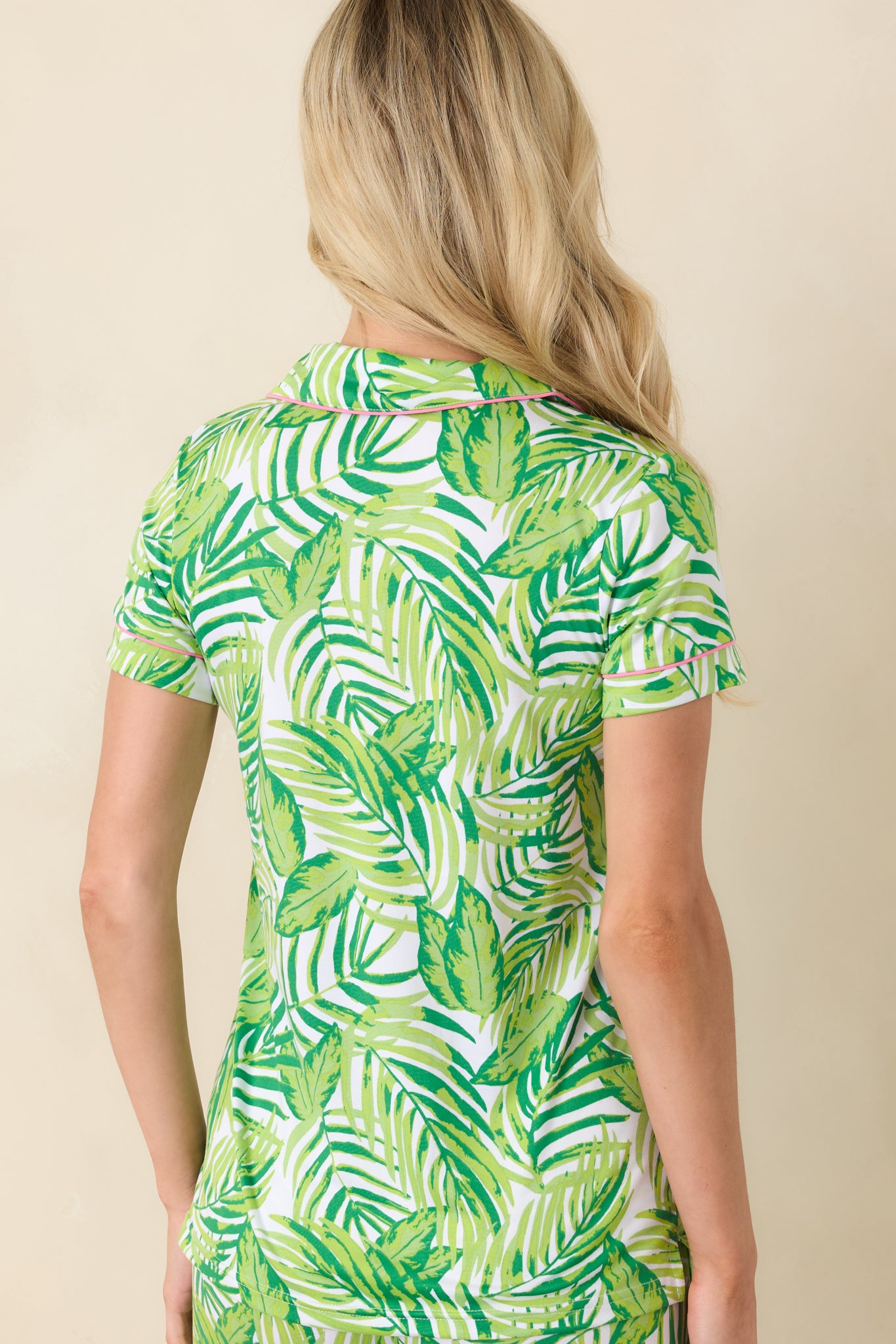 Back view of tropical print top showing relaxed silhouette, short sleeves, and smooth fabric drape