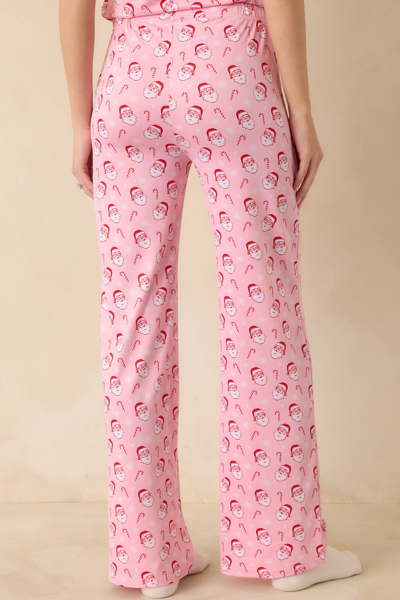 Back view of the pajama pants displaying the allover Santa and candy cane print and relaxed fit.