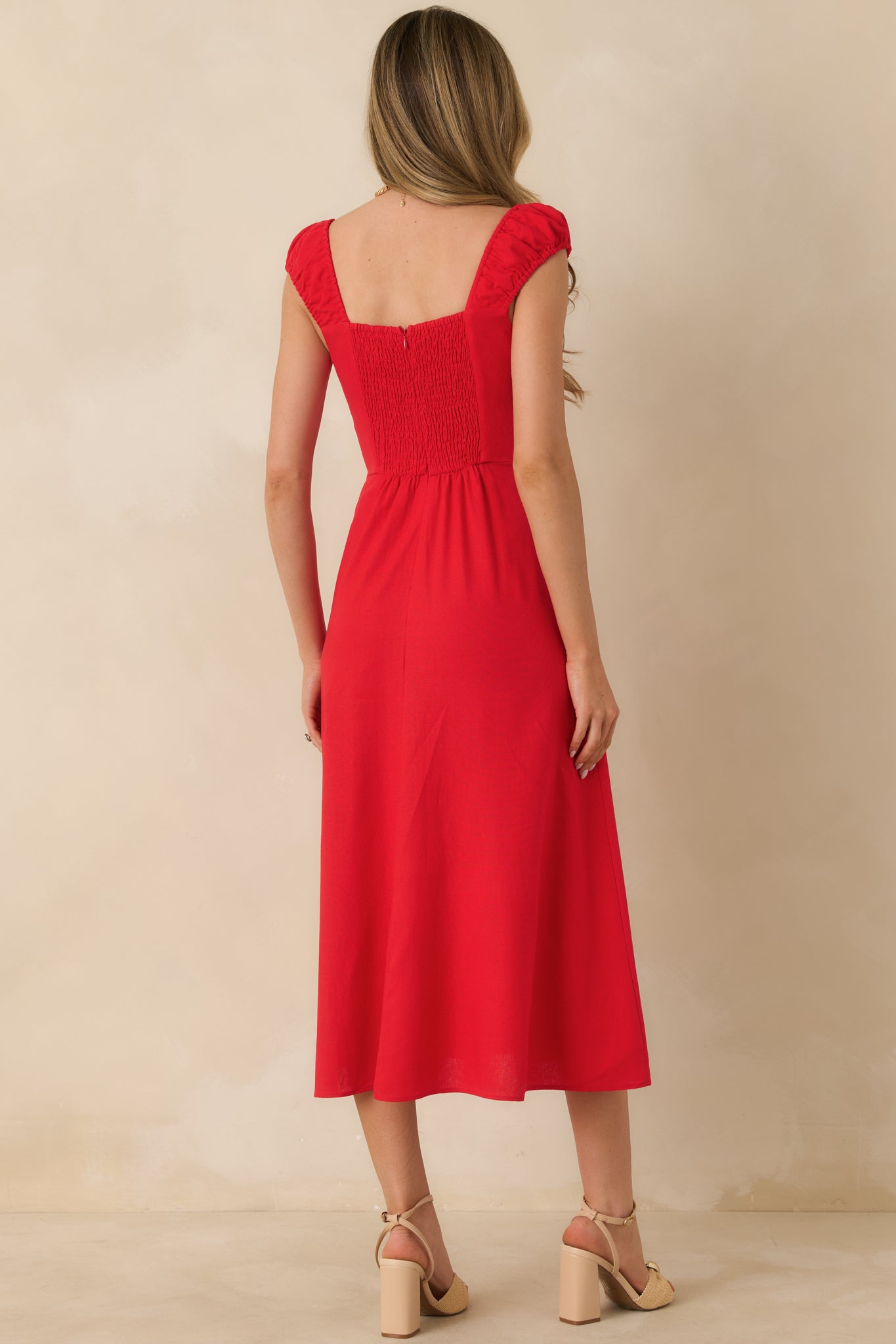 Back view of red midi dress showing smocked back panel and hidden zipper closure.