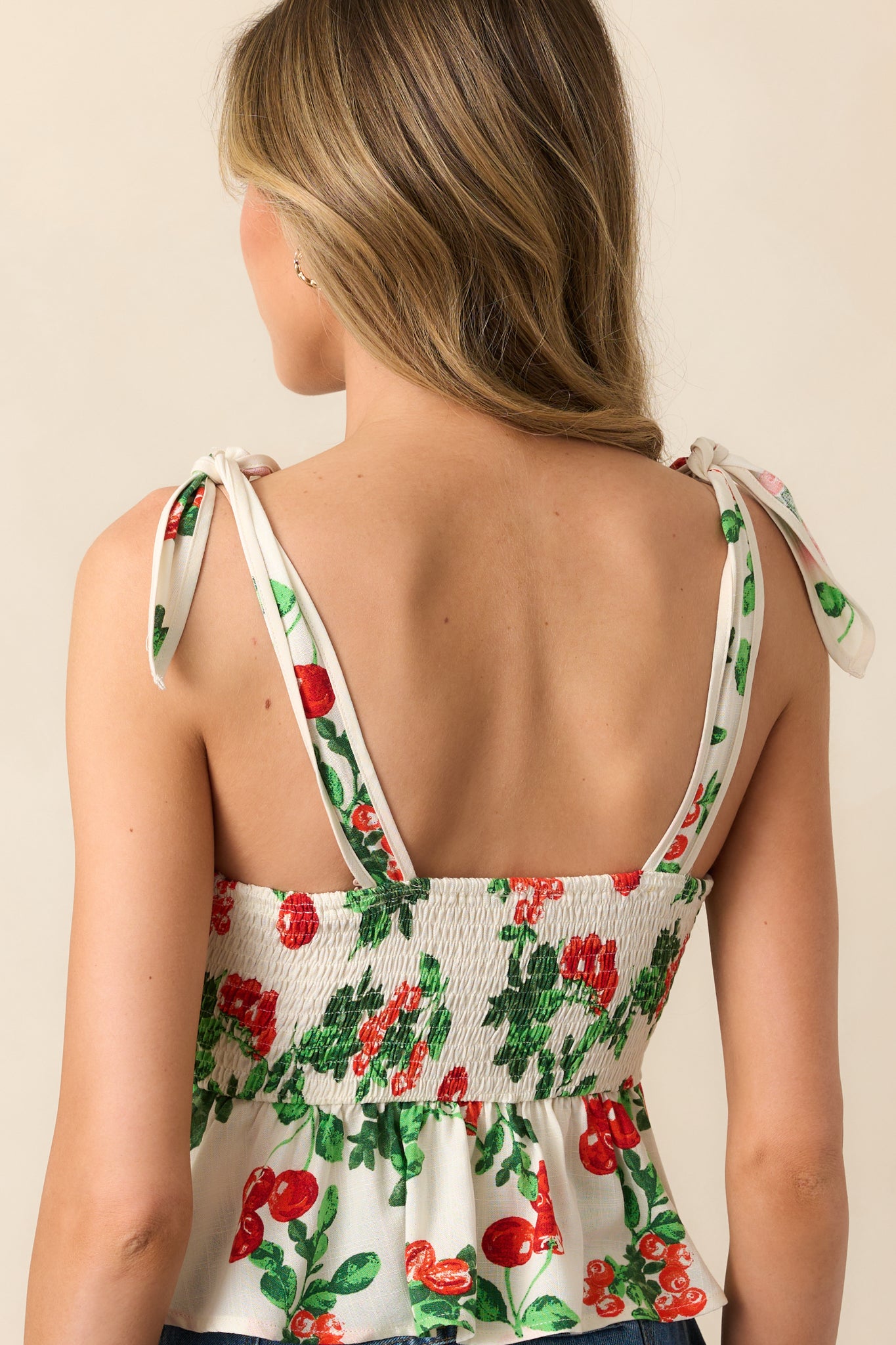 The back view reveals the smocked panel, offering a comfortable fit, and the adjustable straps complement the overall design of this ivory top.