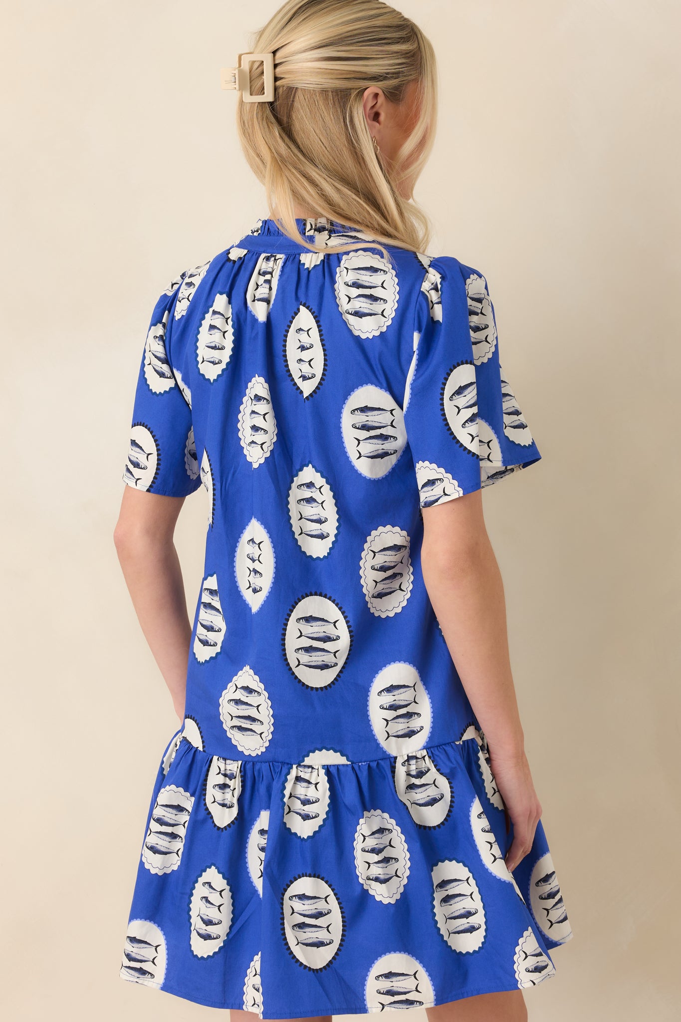 Back view of the mini dress showing relaxed fit, wide short sleeves, and softly tiered hemline.