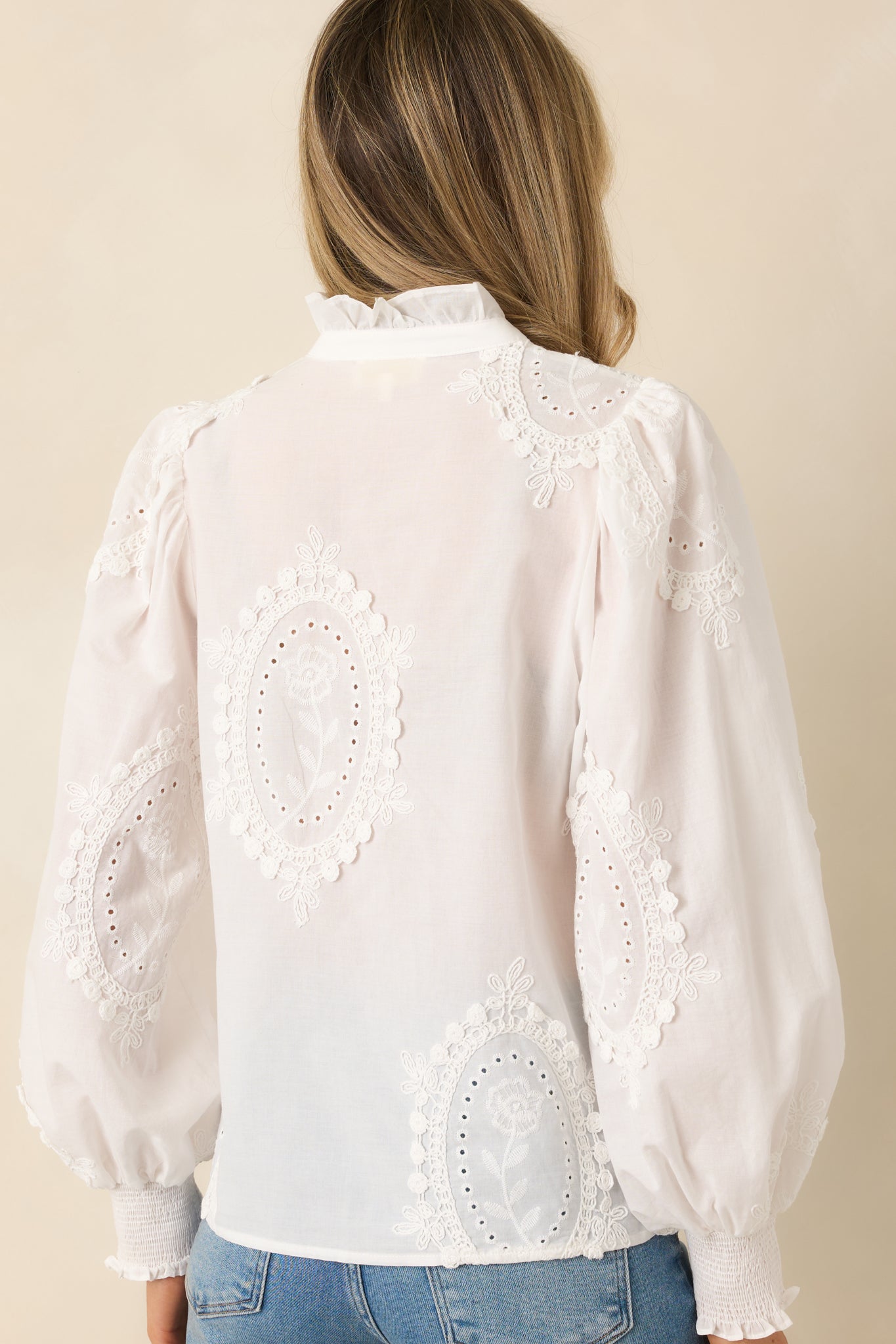 Back view of the white cotton blouse showing the smooth woven fabric and long sleeve design.