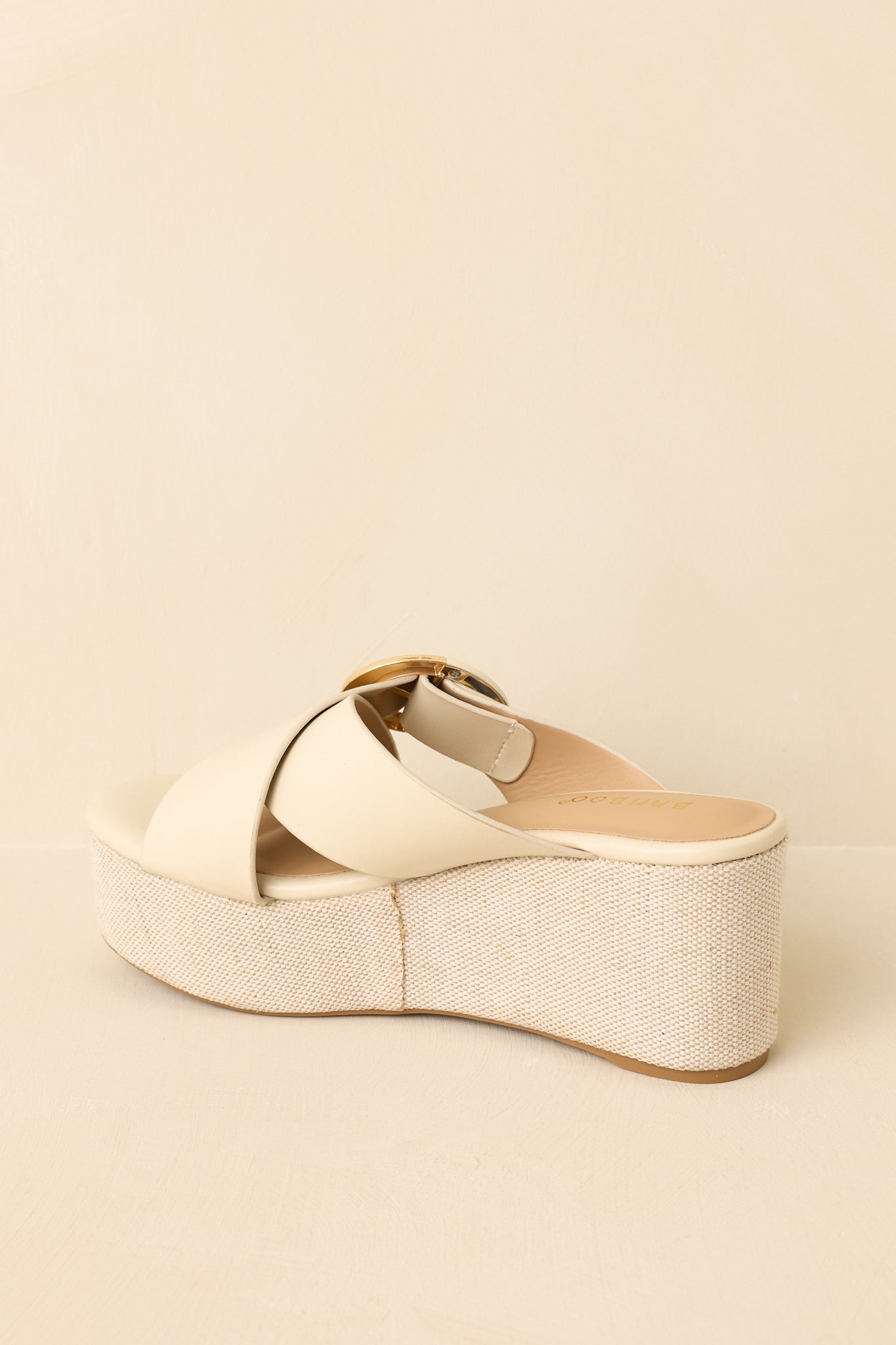 Back view of ivory faux leather platform wedge sandals showcasing the textured wedge heel and slip-on construction.