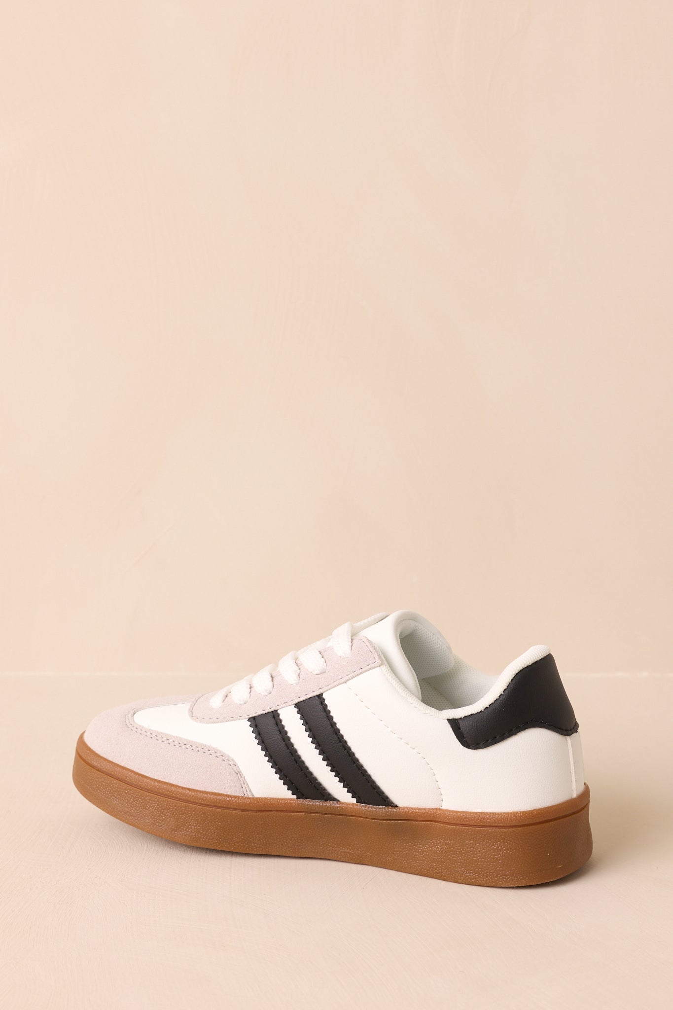 Back view of the sneaker highlighting the heel panel structure and gum rubber sole extending upward at the back.