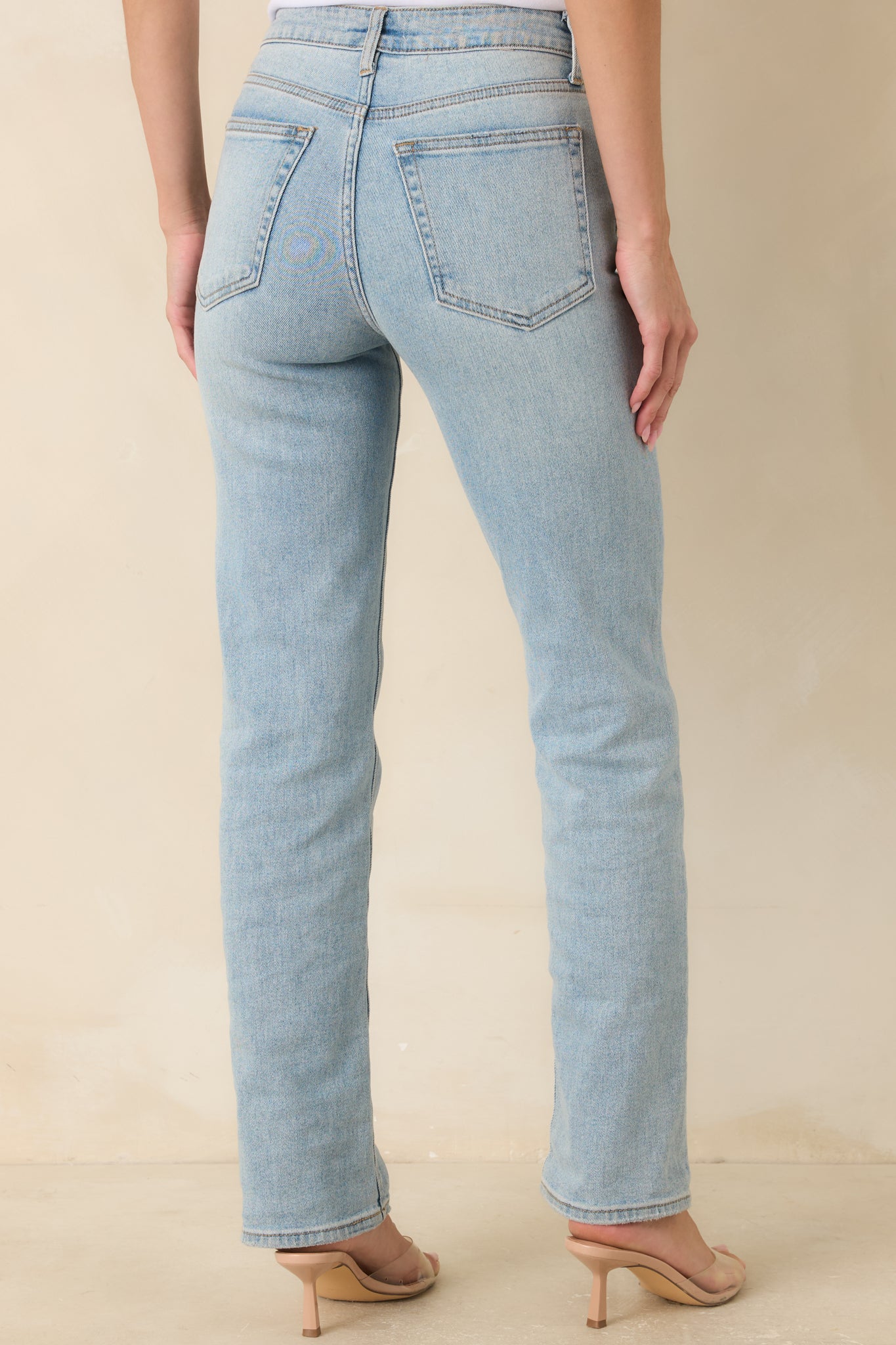 Back view of straight leg jeans featuring functional back pockets, high waisted fit, and clean denim design.