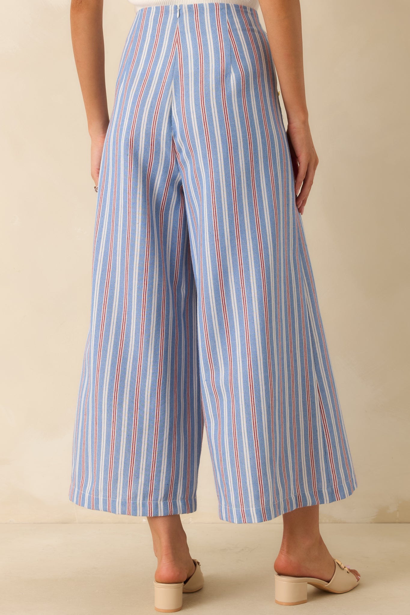Back view of the blue, red, and ivory striped high-rise pants featuring a smooth fitted waist and cropped wide leg silhouette.