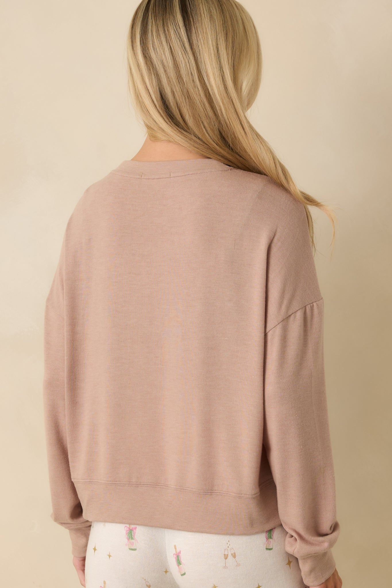 Back view of the taupe knit top showing relaxed silhouette and smooth fabric finish.