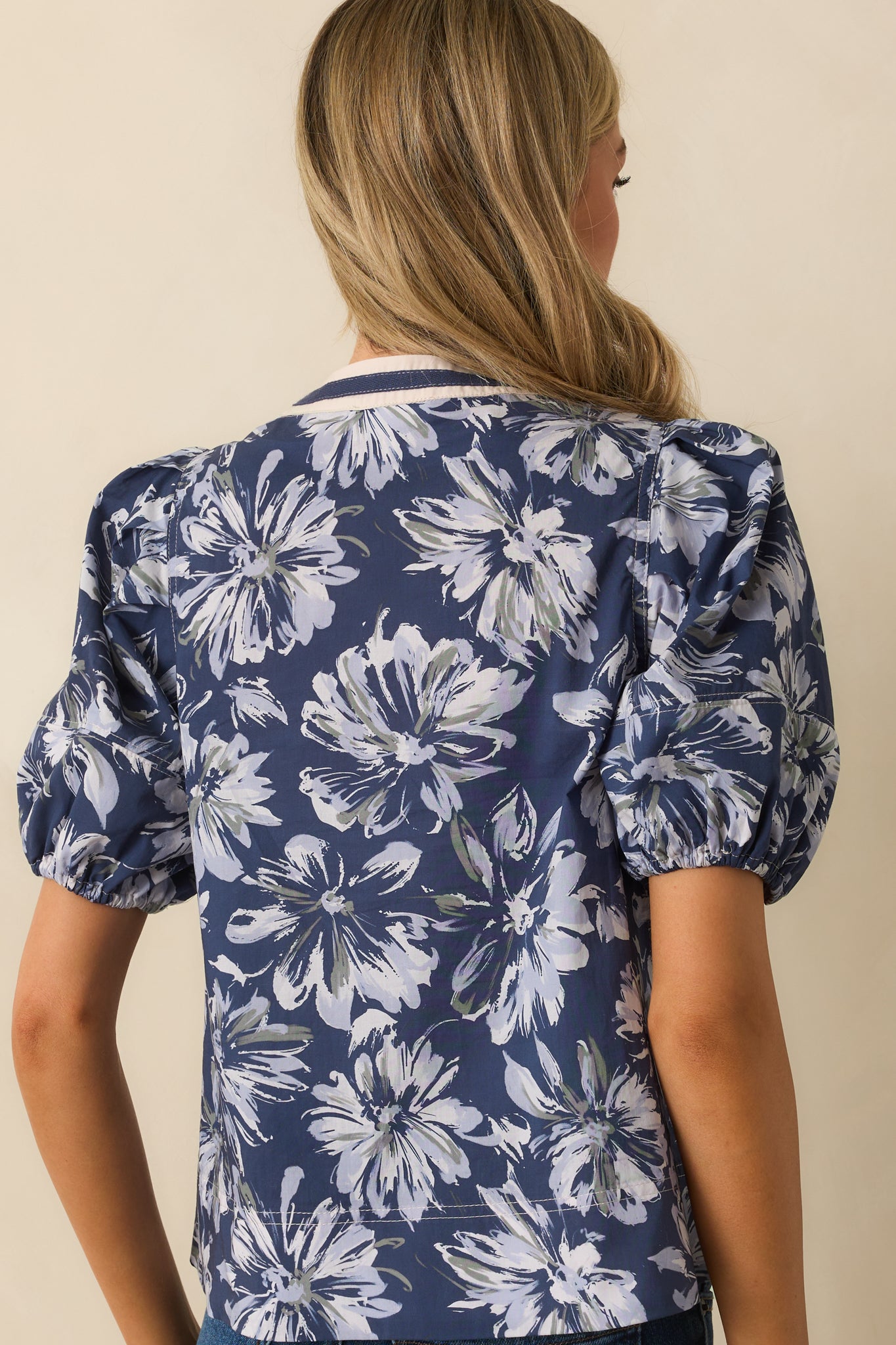 A back view of the top showing the full floral print, puff sleeves, and slightly relaxed fit.