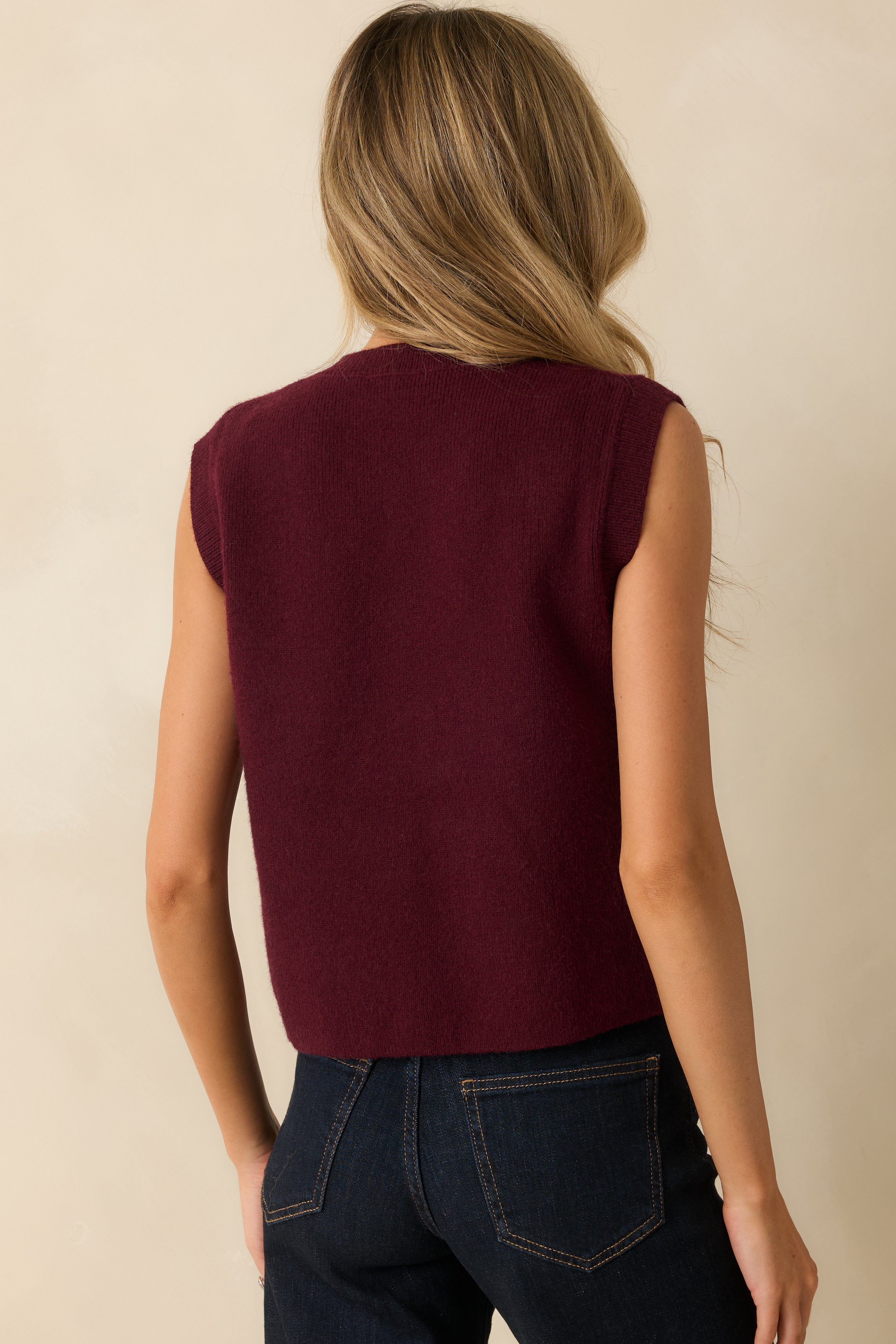 Back view of the vest displaying the smooth knit back and sleeveless cut.