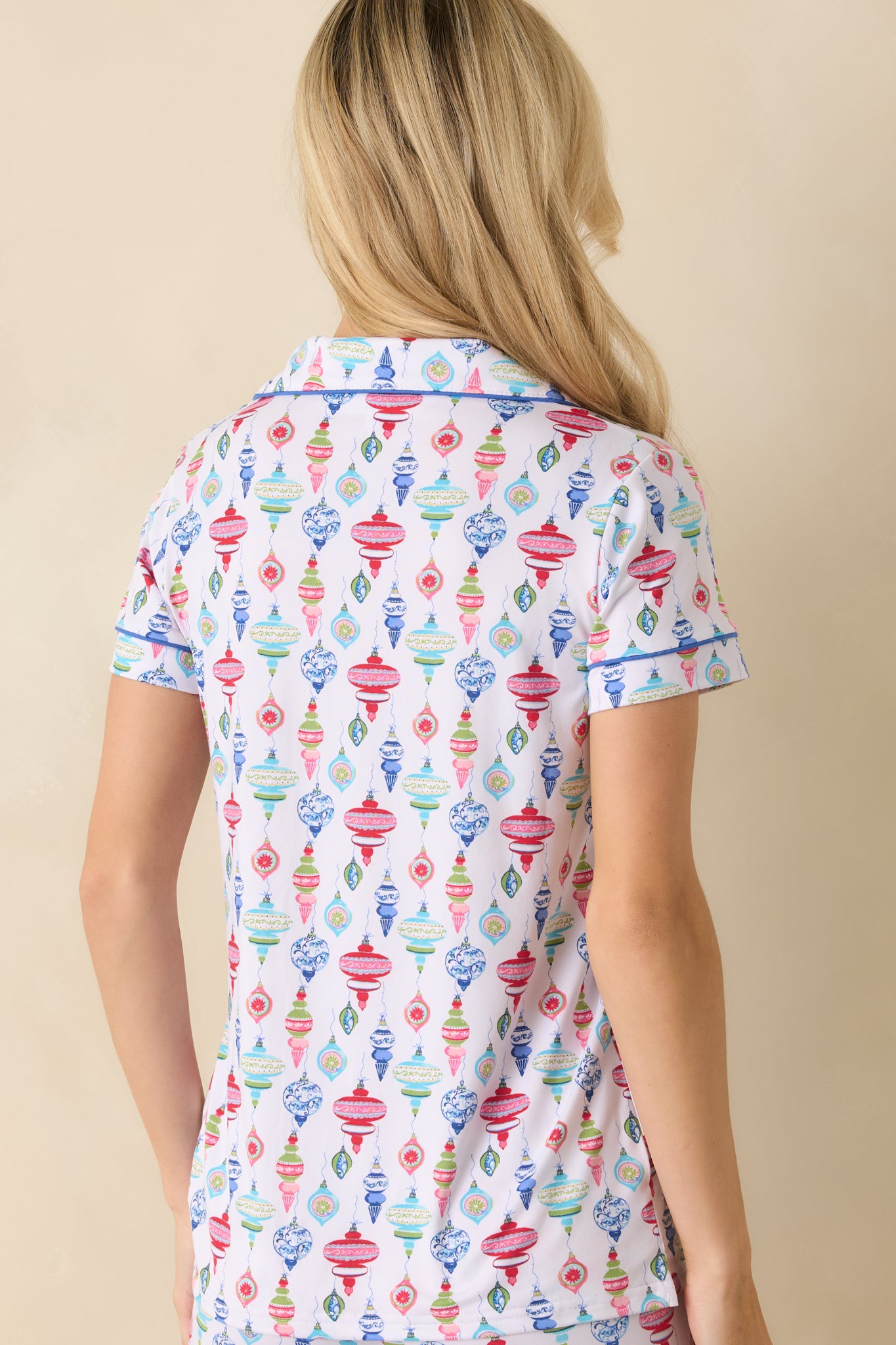 Back view of the white pajama top displaying the colorful ornament print and smooth finish.