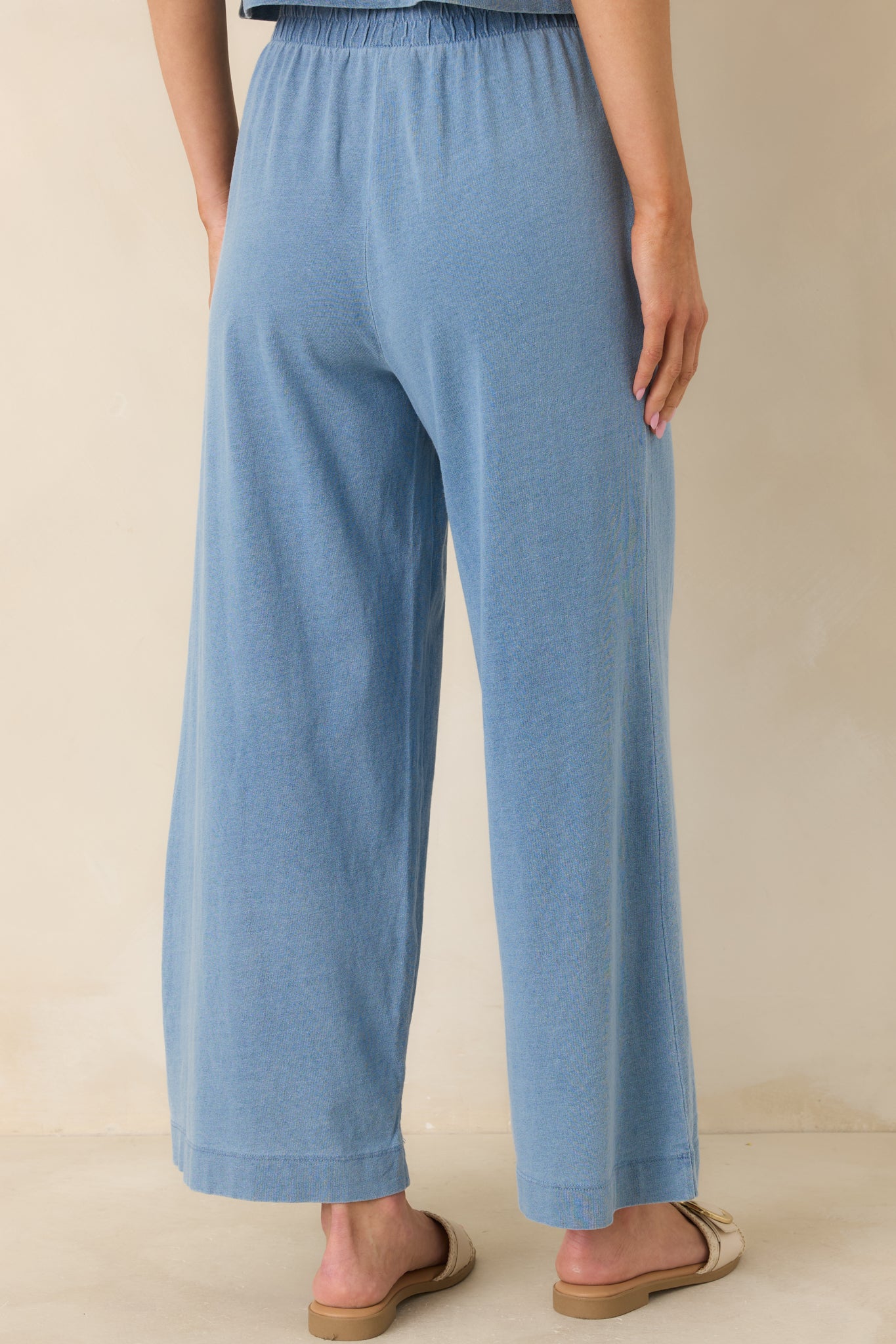 Back view of the washed indigo pants showing the wide-leg cropped silhouette and relaxed fit.