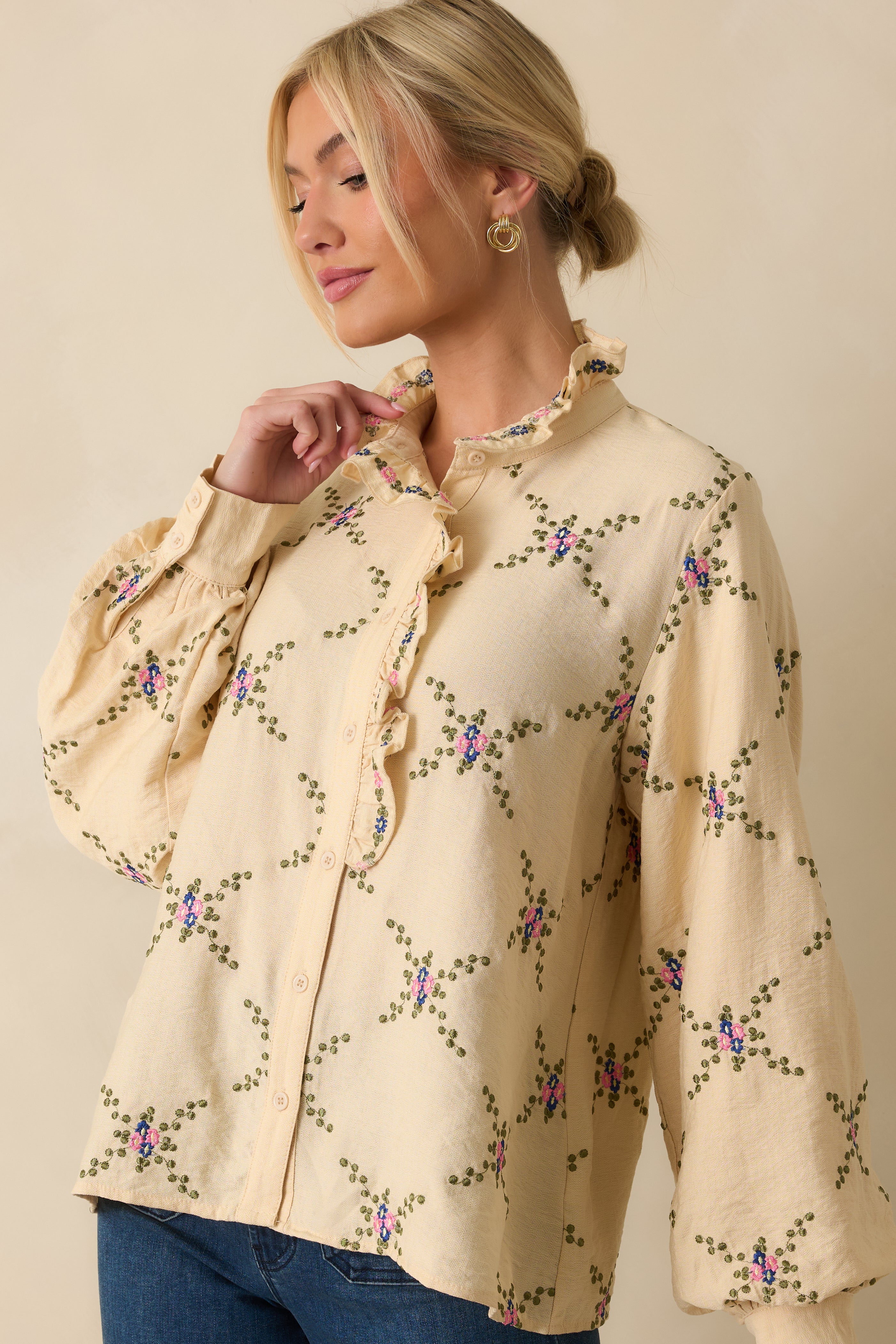 Detail of the balloon sleeve and buttoned cuff showing embroidered floral accents.
