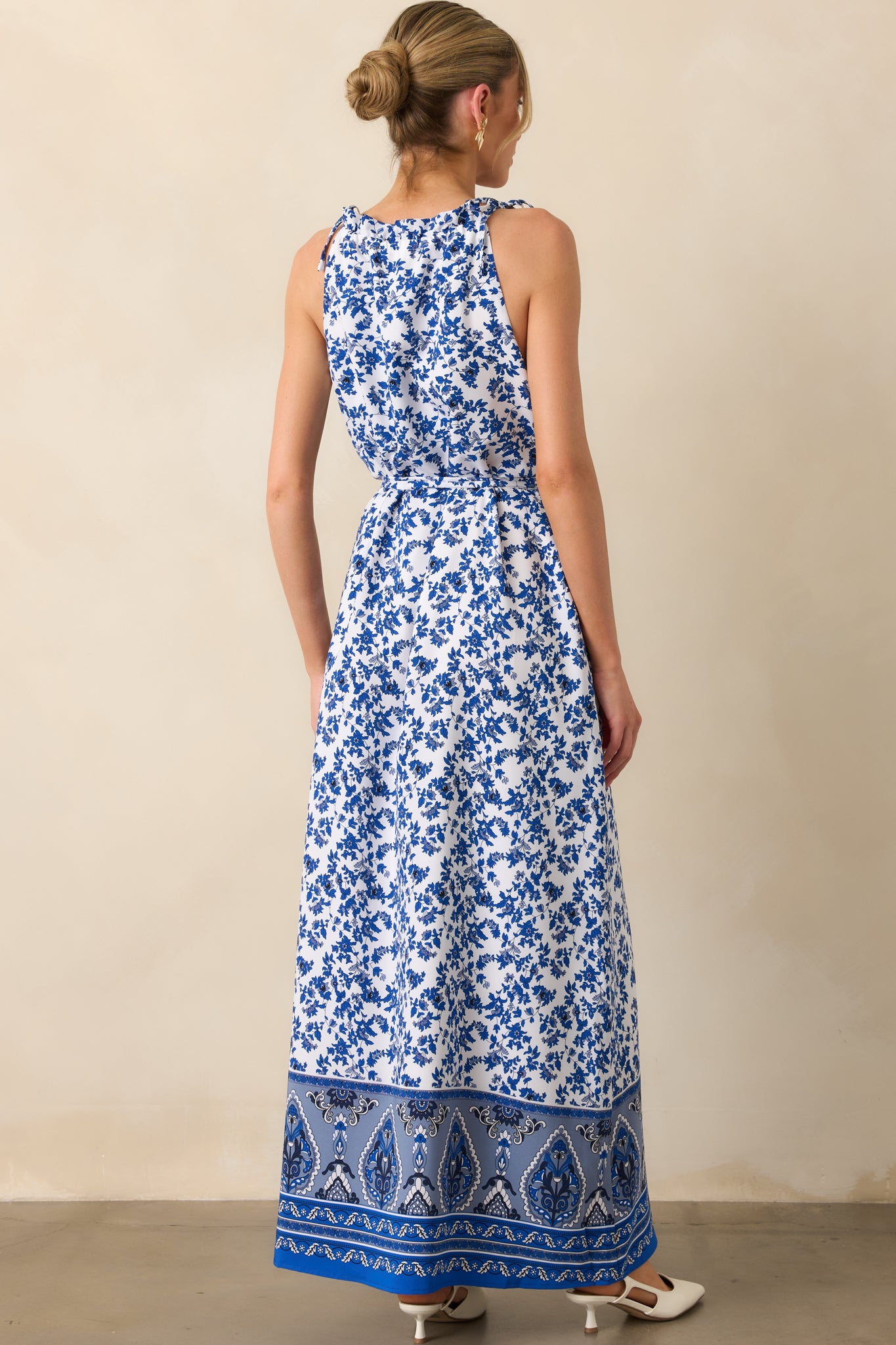 A view from behind displaying the tied shoulder straps and the continued blue floral pattern across the dress.